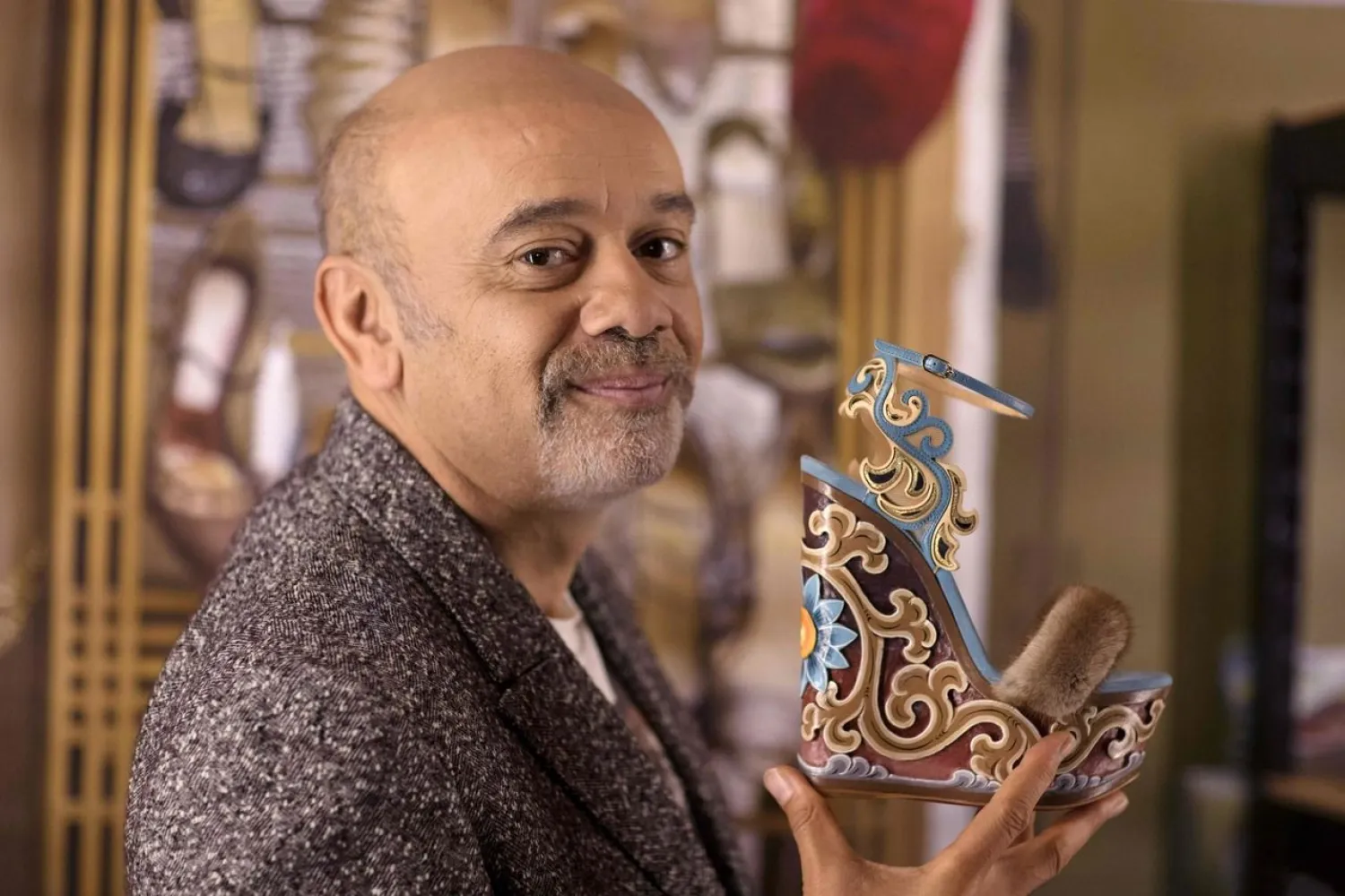 French shoe designer Christian Louboutin poses with one of his creations during a photo session at the Palais de la Porte Doree in Paris a few days before the opening of his exhibition. PHOTO: AFP