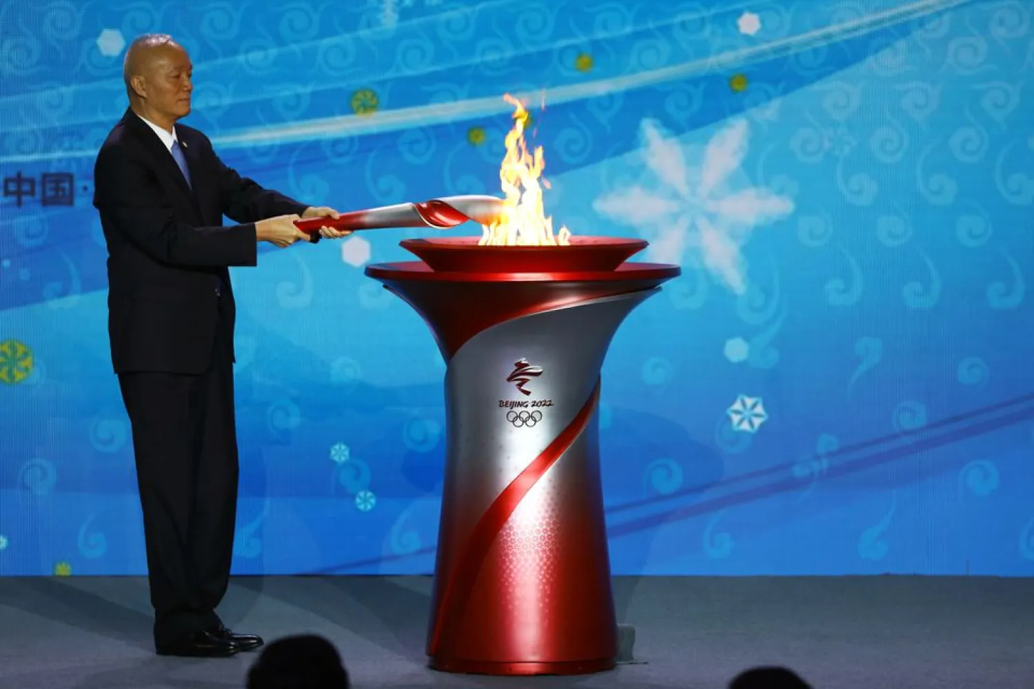 Beijing Communist Party Secretary and President of the Beijing 2022 Organizing Committee Cai Qi transfers the Olympic flame to a cauldron at the ceremony to welcome the flame for the Beijing 2022 Winter Olympics, in Beijing, China October 20, 2021. REUTERS/Tingshu Wang



