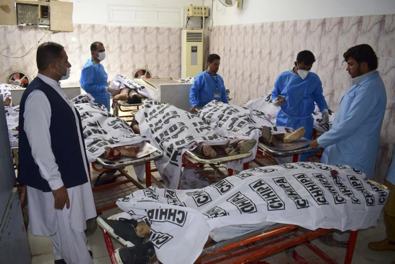 File Photo - Pakistani paramedical personnel stand next to the covered bodies of suspect militants who were killed by security forces, at a morgue in Quetta, Pakistan, Aug. 31, 2021. (AP Photo/Arshad Butt)
