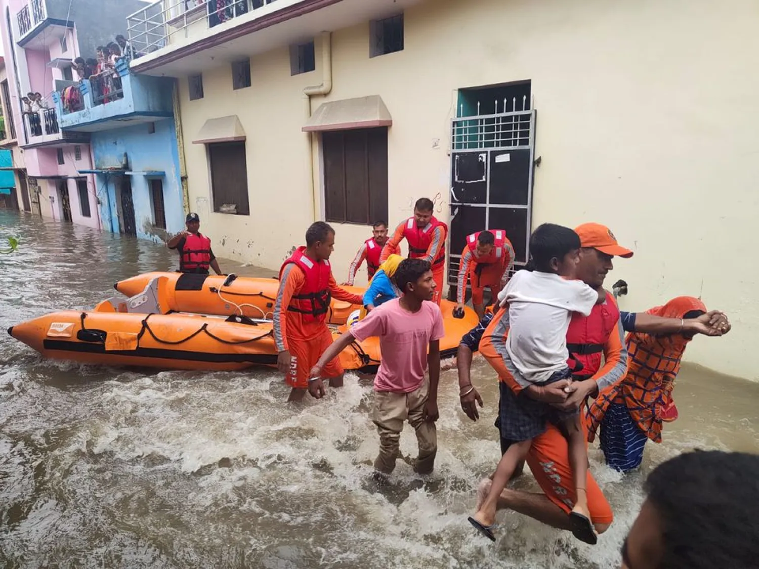 Members of National Disaster Response Force (NDRF) evacuate people to safer places from a flooded area in Udham Singh Nagar in the northern state of Uttarakhand, India, October 19, 2021. National Disaster Response Force/Handout via REUTERS



