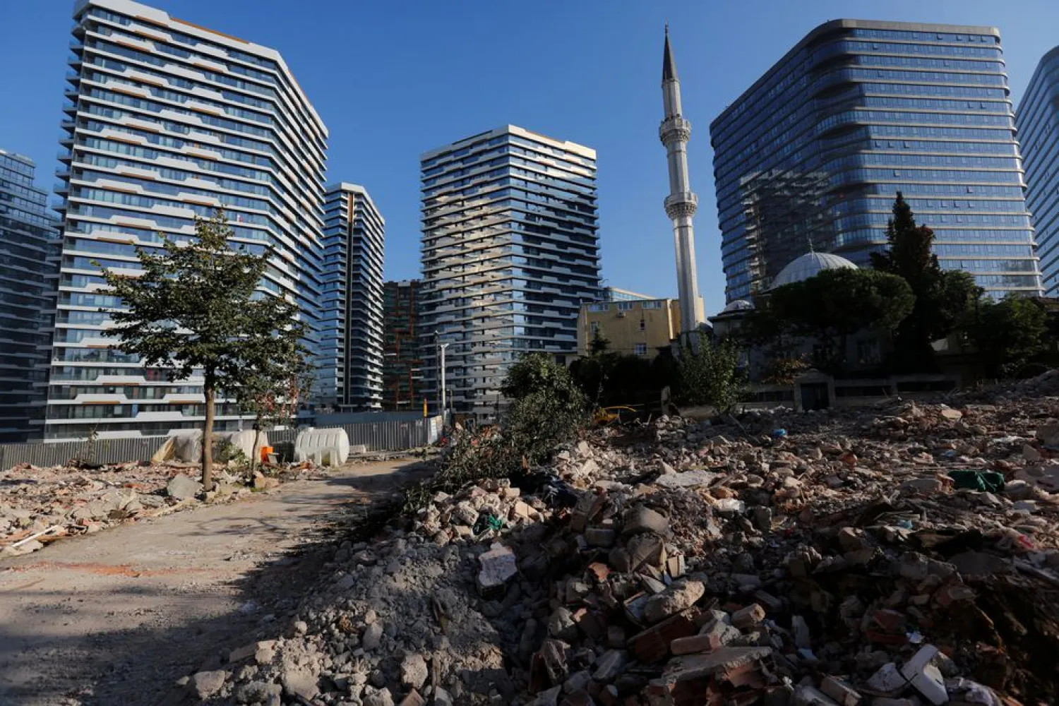 Debris from houses is seen in front of brand new residential buildings at an urban transformation project area in Istanbul, Turkey October 22, 2021. (Reuters)