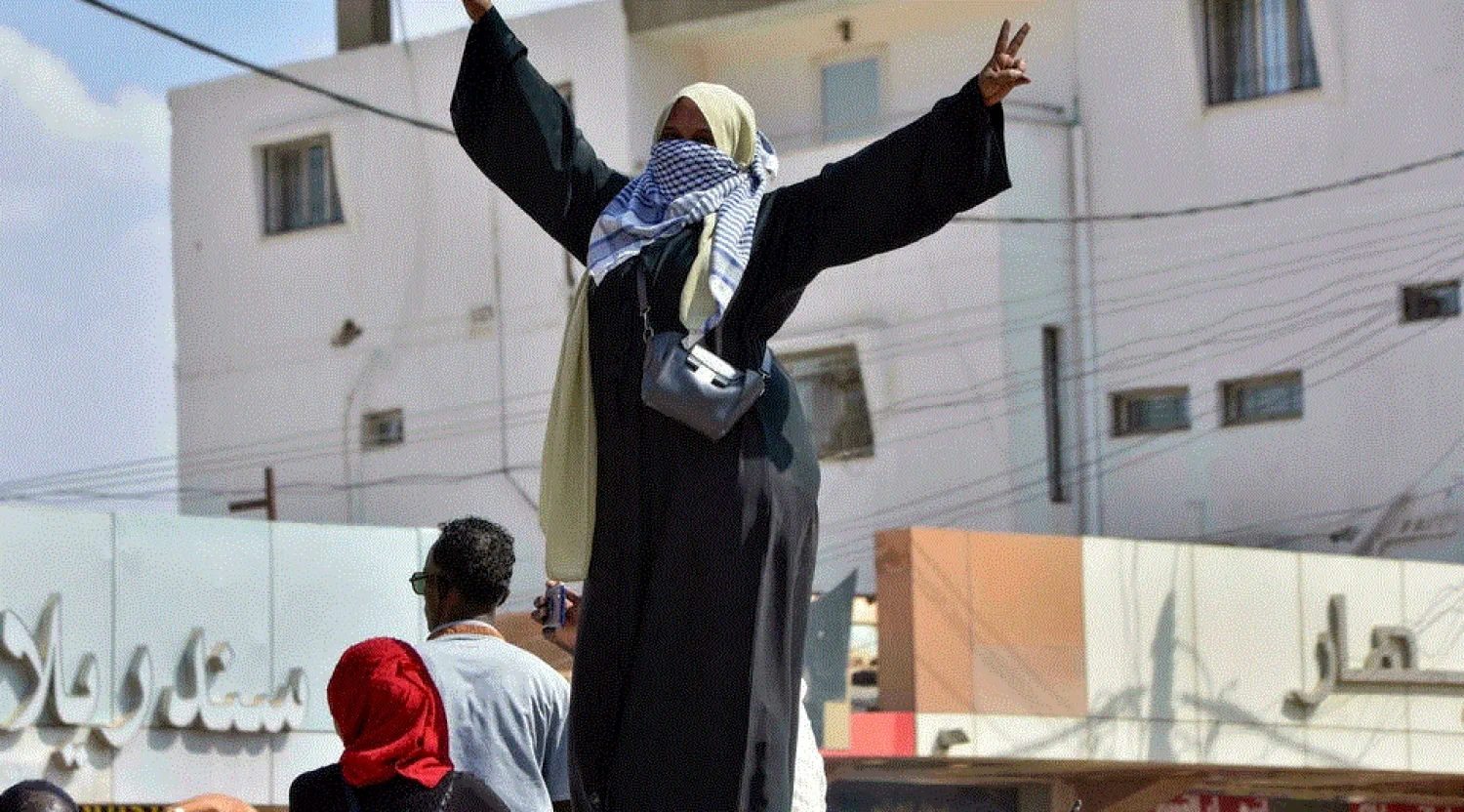 A Sudanese woman takes part in a protest in Khartoum Bahri to demand the government's transition to civilian rule, one of tens of thousands who took to the streets in recent days - AFP
