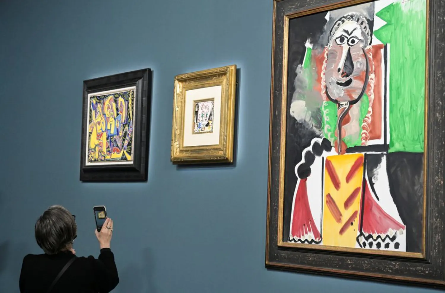 An attendee photographs a painting prior to the auction of 11 Picasso paintings and works at the Bellagio Hotel in Las Vegas, Nevada, US October 23, 2021. (Reuters)