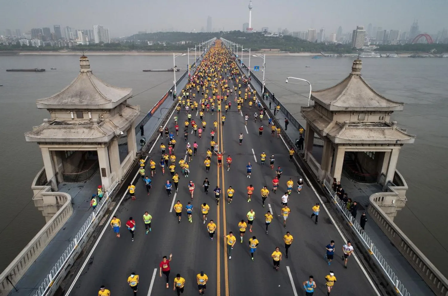 Wuhan marathon runners cross the Yangtze River bridge in 2018. This year's event was postponed at short notice because of Covid fears. STR AFP
