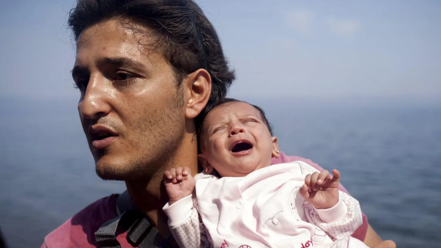 A Syrian refugee from Aleppo holds his one month old daughter moments after arriving on a dinghy on the Greek island of Lesbos. Reuters file photo