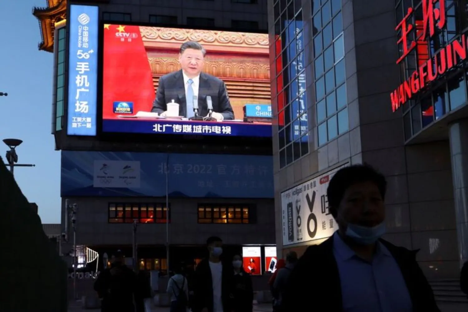 A giant screen shows news footage of Chinese President Xi Jinping attending a video summit on climate change with German Chancellor Angela Merkel and French President Emmanuel Macron, at a shopping street in Beijing, China April 16, 2021. (Reuters)