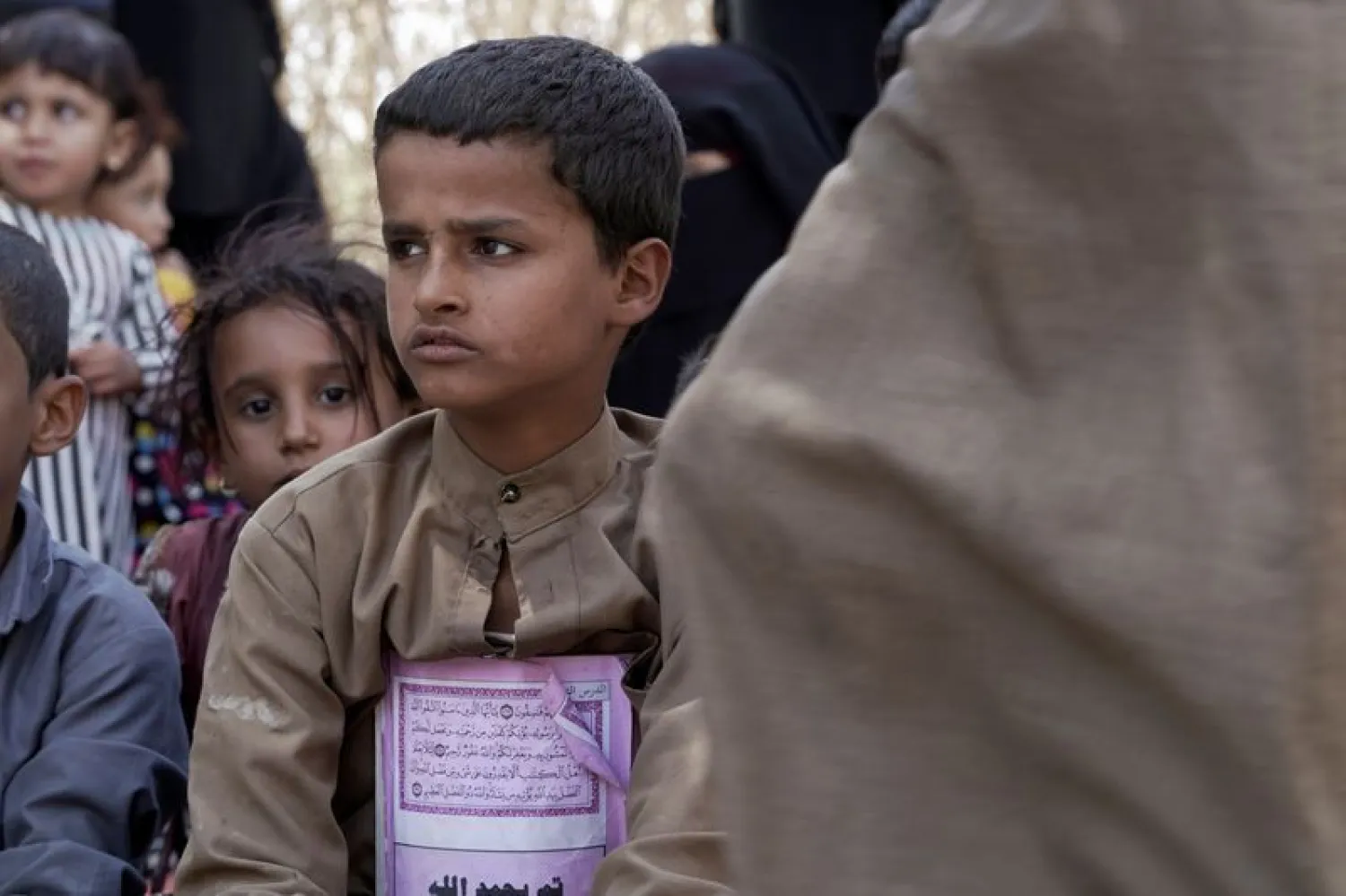 Children and women sit outside a hut at a camp for internally displaced people (IDPs) on the outskirts of Marib city (Reuters)