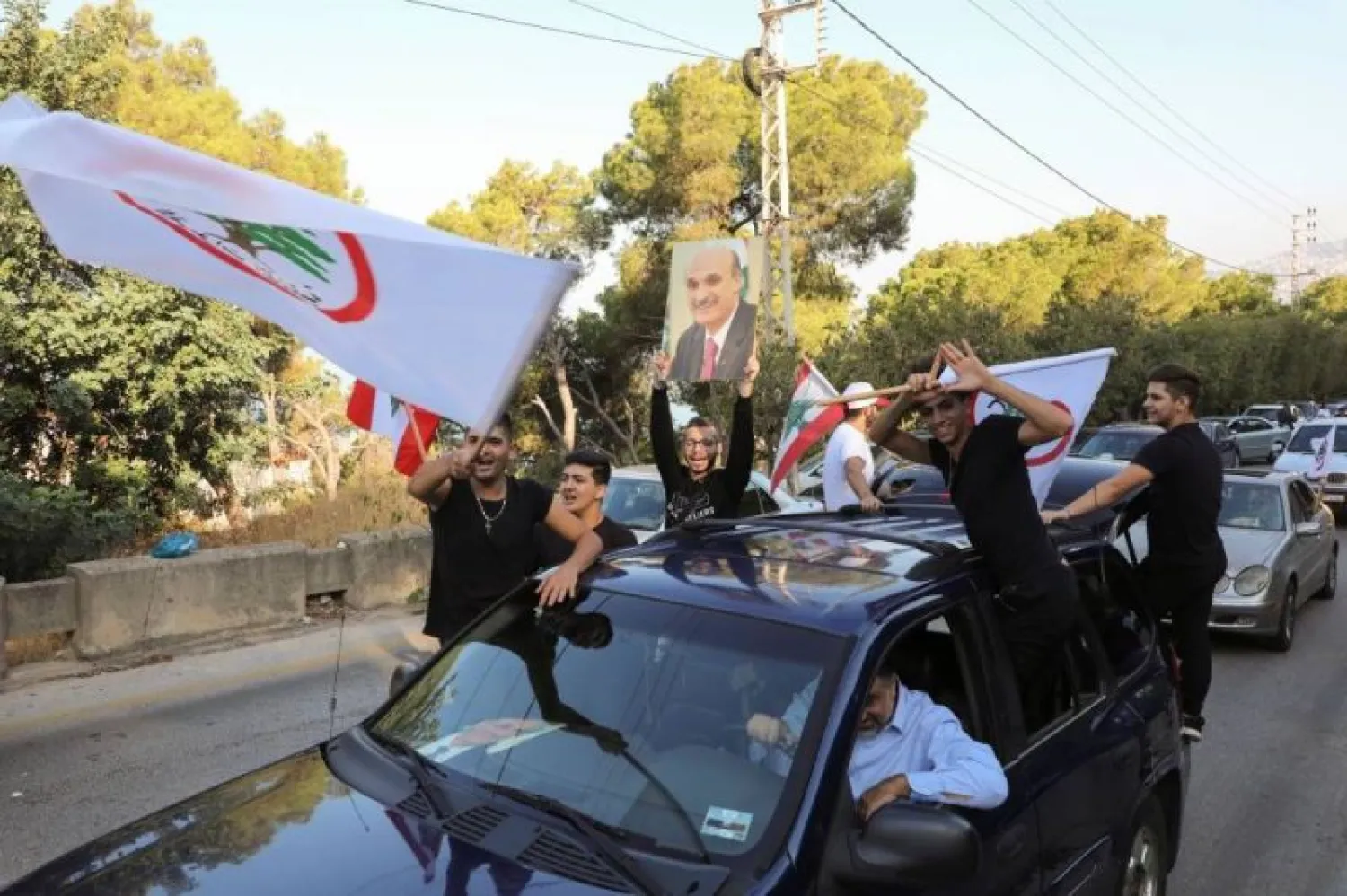 Supporters of the Lebanese Forces hold flags during a protest against the summoning of party leader Samir Geagea for a hearing by army intelligence over the Oct. 14 Beirut clashes. (Reuters)