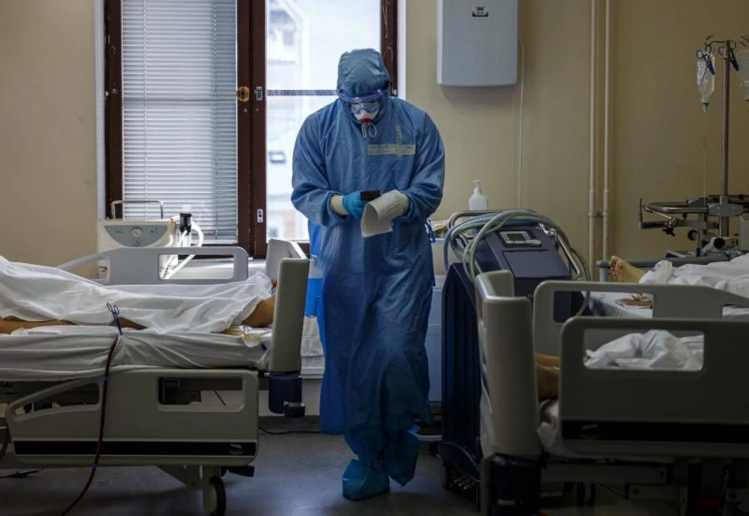 ممرض يرتدي الملابس الواقية خلال اهتمامه بمرضى «كورونا» في مستشفى بروسيا (أ.ف.ب)