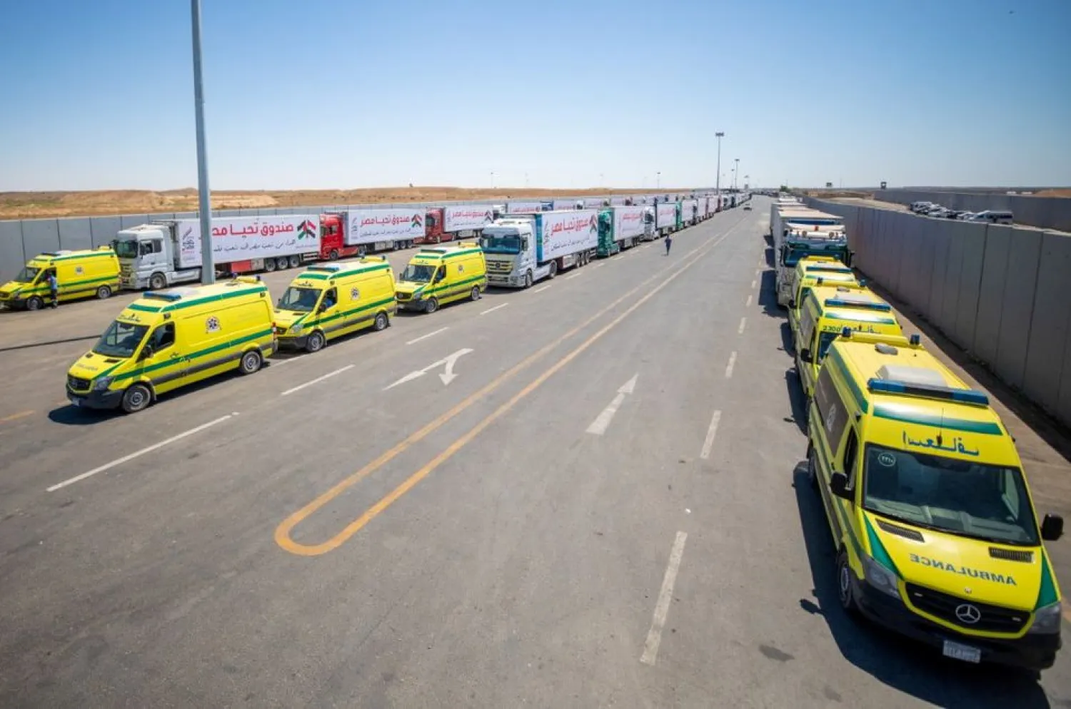 Ambulances and an aid convoy's trucks loaded with supplies, sent by Long Live Egypt Fund, are seen at the Rafah border crossing between Egypt and the Gaza Strip, in this handout picture obtained by Reuters on May 23, 2021. The Egyptian Presidency/Handout via REUTERS