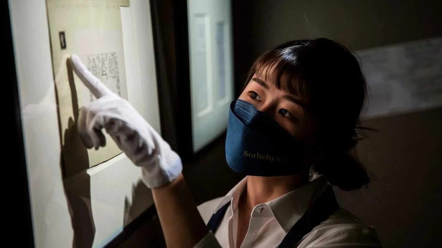 A staff member points to the worlds first postage stamp at
Sothebys in Hong Kong (Image: AFP via Getty Images)
