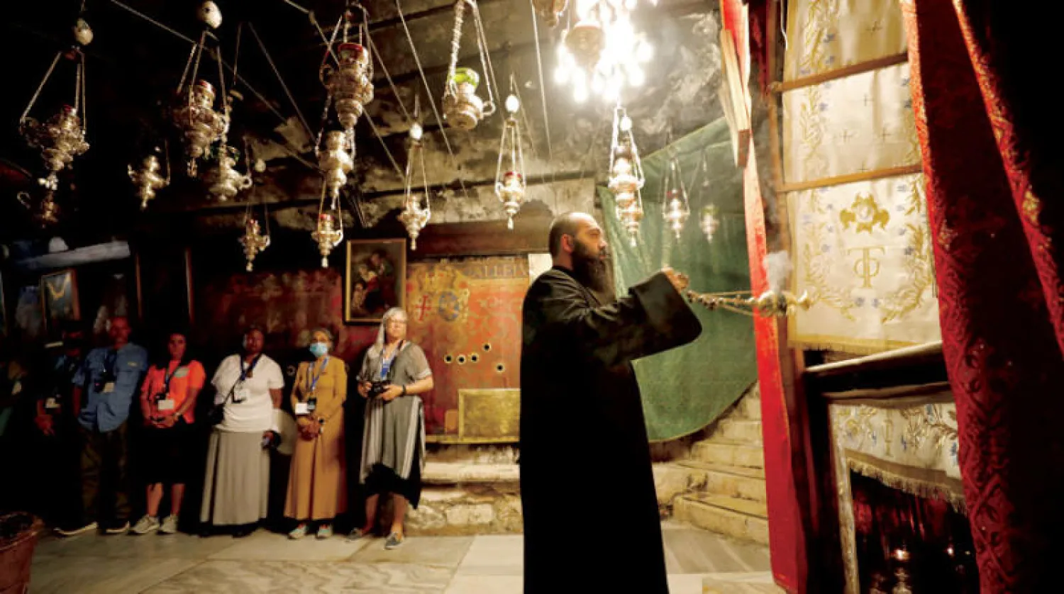 سياح أجانب صيف هذا العام داخل كنيسة المهد في بيت لحم بالضفة (رويترز)