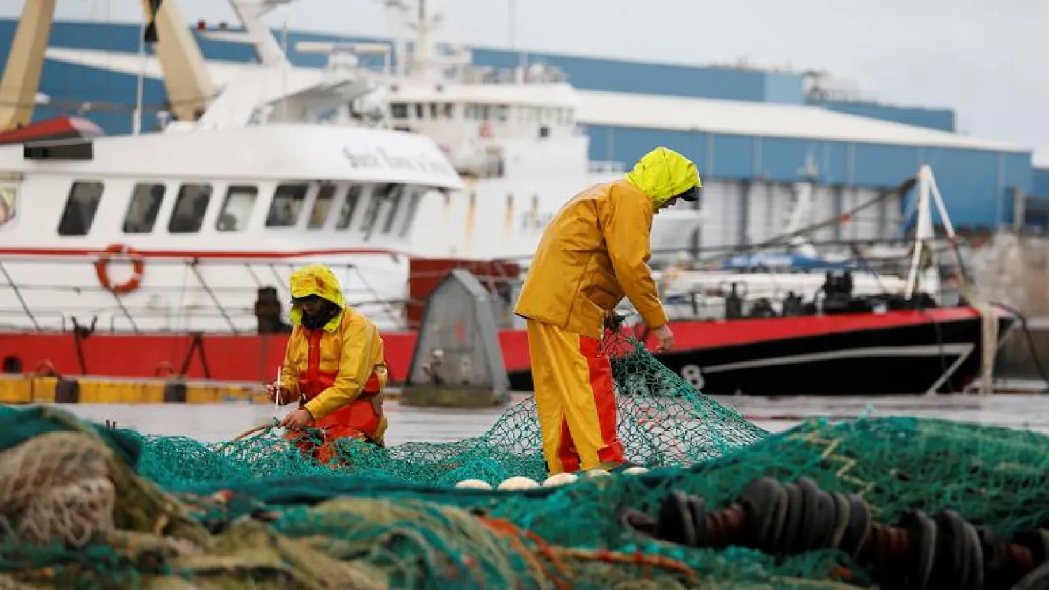 French fishermen repair their nets at Boulogne-sur-Mer - Credit: CHARLES PLATIAU/REUTERS
