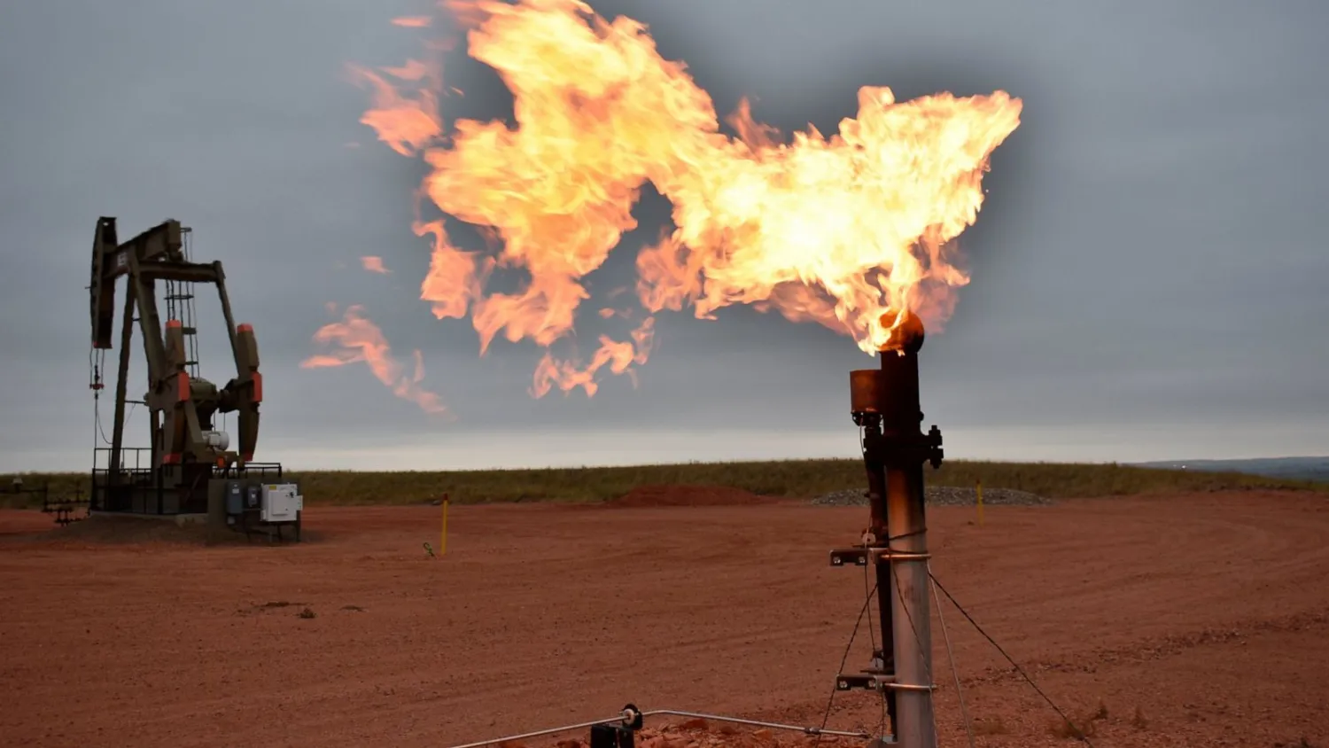 FILE - A flare burns natural gas at an oil well on Aug. 26, 2021, in Watford City, United States. (AP Photo/Matthew Brown, File)
