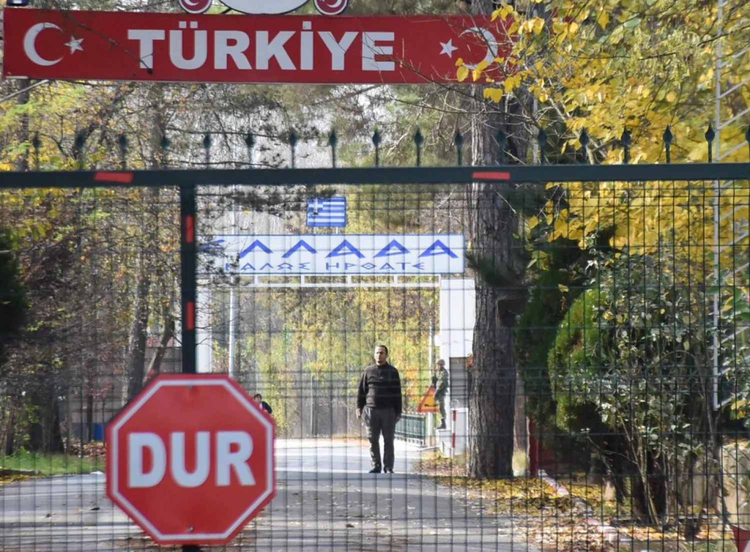 A man (C), allegedly a US citizen and a member of the ISIS group, who was deported by Turkish officials and rejected by Greek police, standing in a no man's land at the border between Turkey and Greece near Pazarkule, is seen from the Turkish side in Edirne, on November 11, 2019. (Photo by DHA / DHA / AFP) / 
