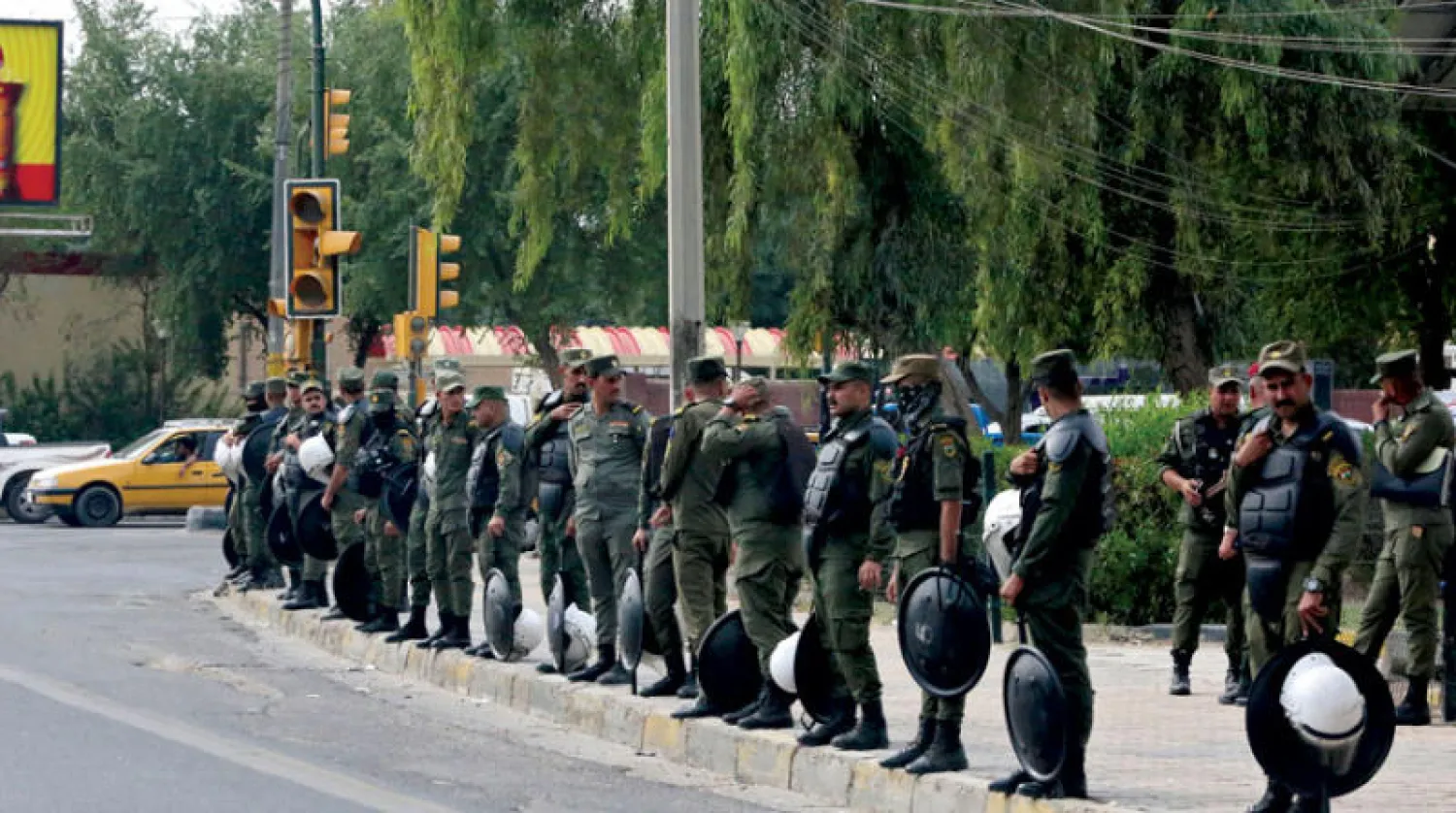 قوة أمنية تنتشر قرب «المنطقة الخضراء» بعد سقوط صواريخ «كاتيوشا» على حي المنصور القريب منها أمس (أ.ف.ب)