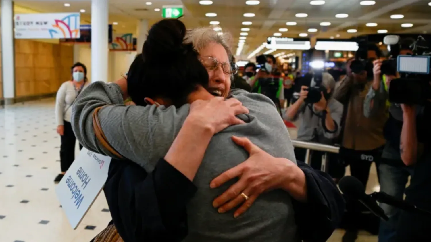 An international traveler is embraced after arriving at Sydney Airport in the wake of coronavirus disease border restrictions easing in Australia on Monday. (Jaimi Joy/Reuters)