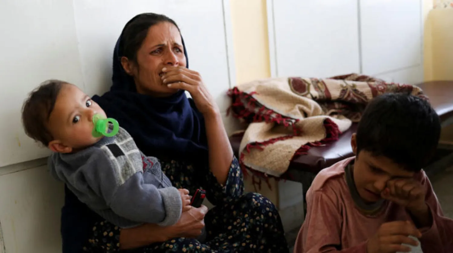 امرأة و أطفالها في «مستشفى أنديرا غاندي للأطفال» خلال الهجوم على المستشفى العسكري في كابل أمس (رويترز)