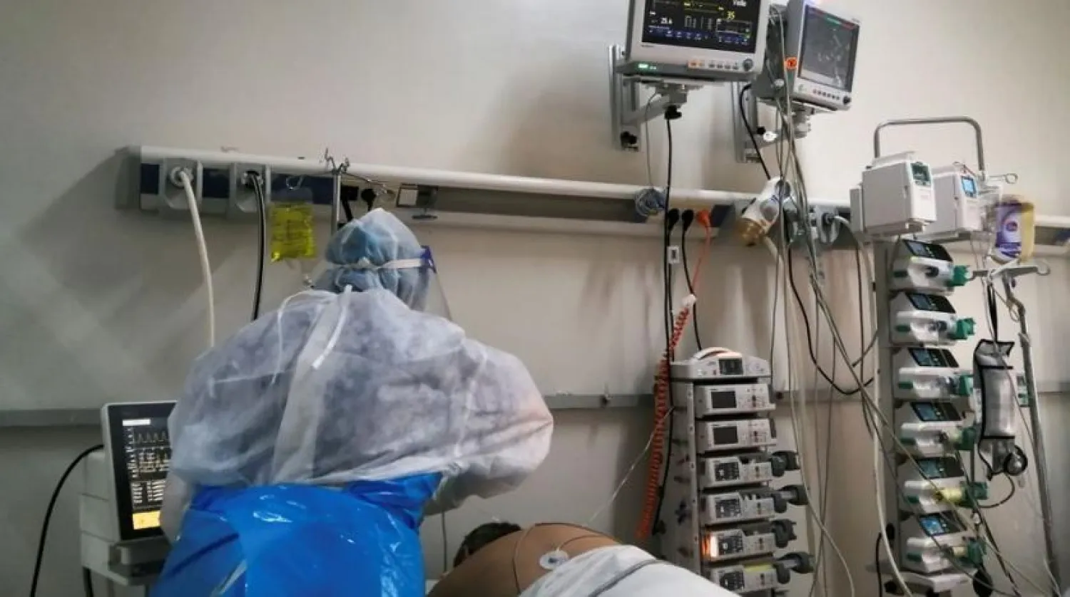 A medical staff member assists a patient suffering from the coronavirus disease (COVID-19), at an intensive care department at a hospital in Ariana, Tunisia, April 26, 2021. (Reuters)