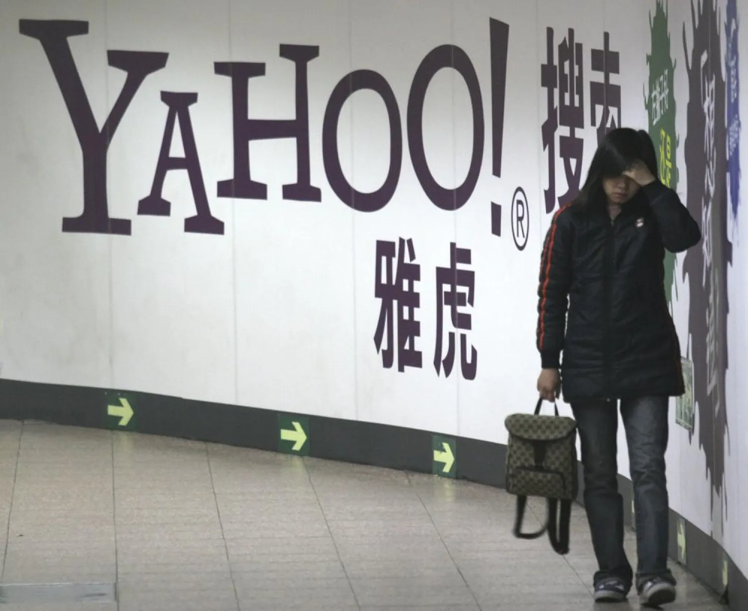 FILE - A woman walks past a Yahoo billboard in a Beijing subway in this March 17, 2006.  (AP Photo, File)
