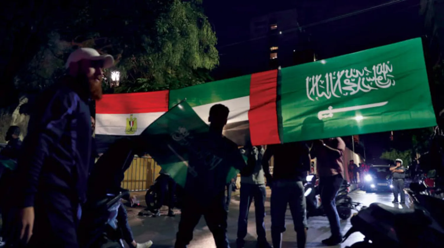 لبنانيون يرفعون في بيروت يوم 30 أكتوبر أعلام السعودية والإمارات ومصر تضامناً مع الإجراءات التي اتخذتها دول الخليج رداً على التصريحات المسيئة لوزير الإعلام اللبناني (أ.ب)