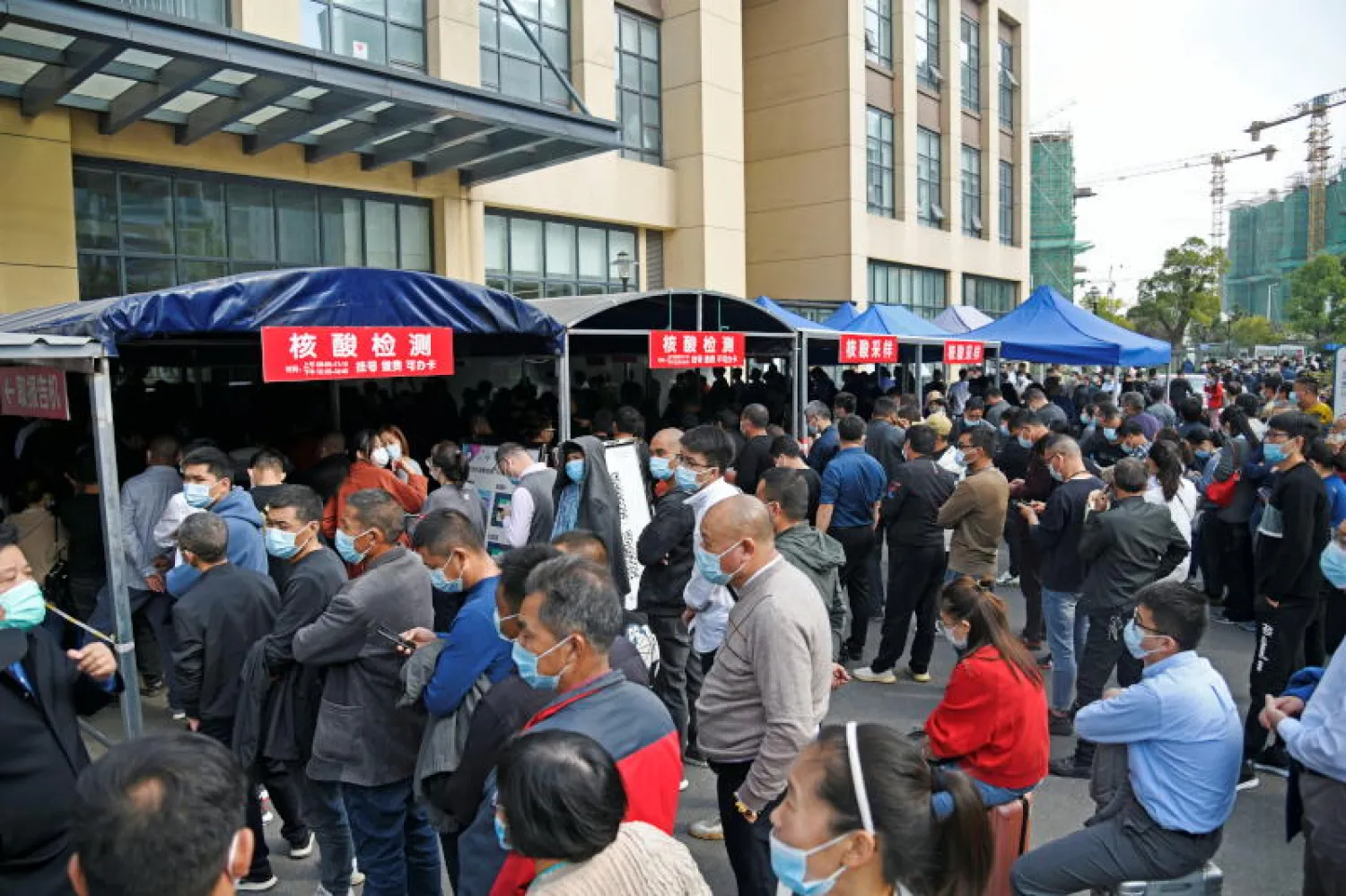 أشخاص يتجمعون لإجراء اختبار الحمض النووي بمستشفى في مدينة تشانغتشو(رويترز)