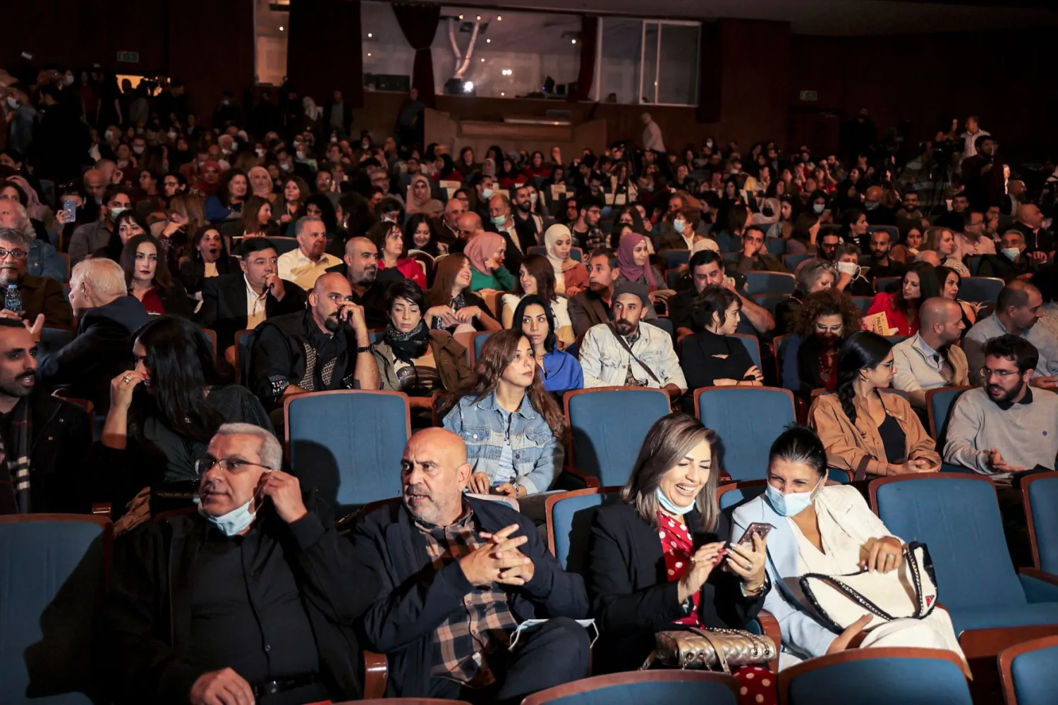 فلسطينيون يشاهدون فيلم «الغريب» في مهرجان «أيام فلسطين السينمائية» برام الله (أ.ف.ب)