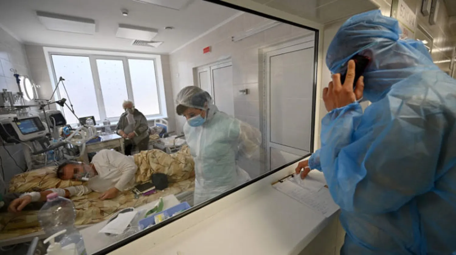 طاقم طبي يتفقد مصاباً بـ«كورونا» في قسم العناية المركزة بكييف الاثنين (أ.ف.ب)