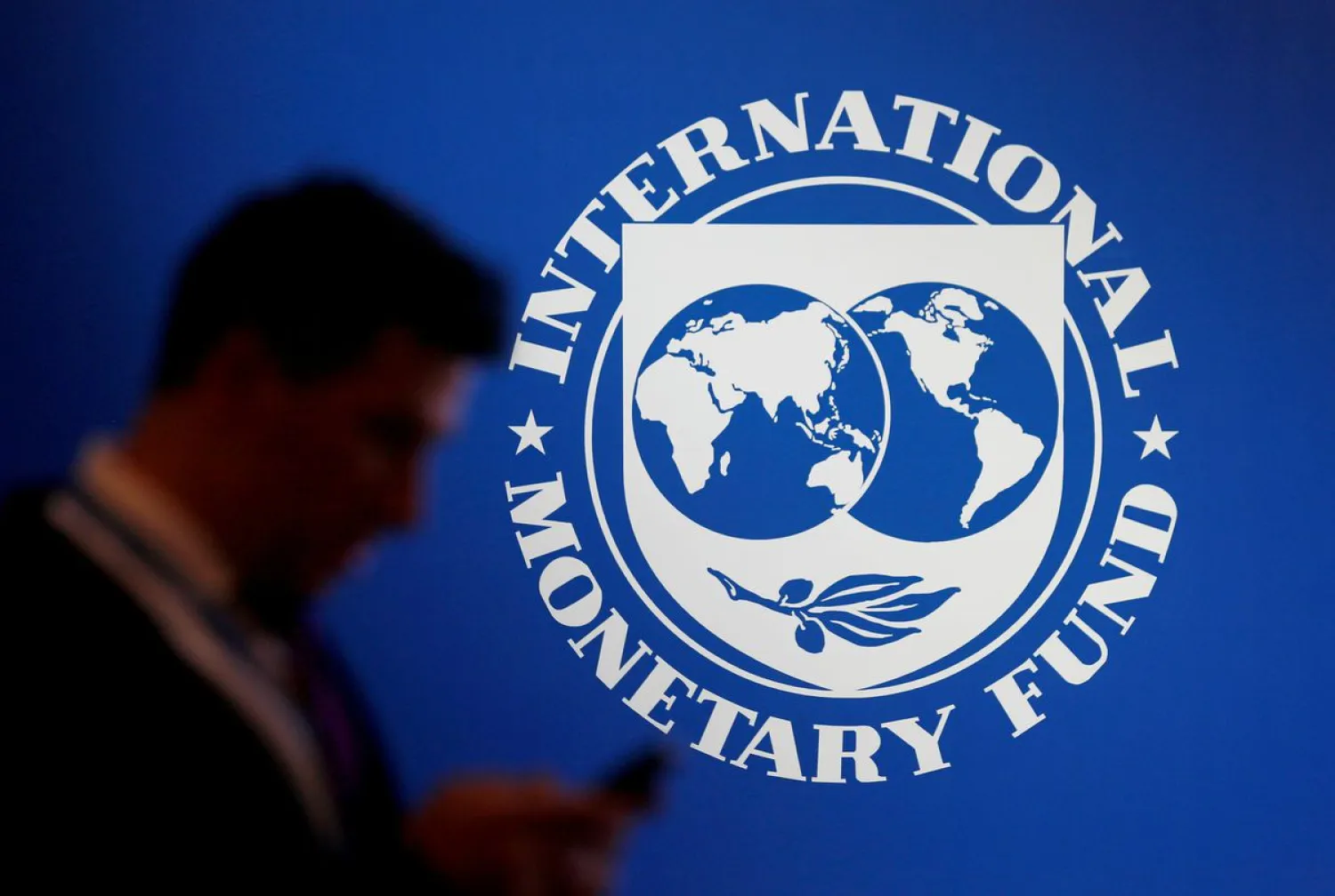 A participant stands near a logo of IMF at the International Monetary Fund - World Bank Annual Meeting 2018 in Nusa Dua, Bali, Indonesia, October 12, 2018. Reuters
