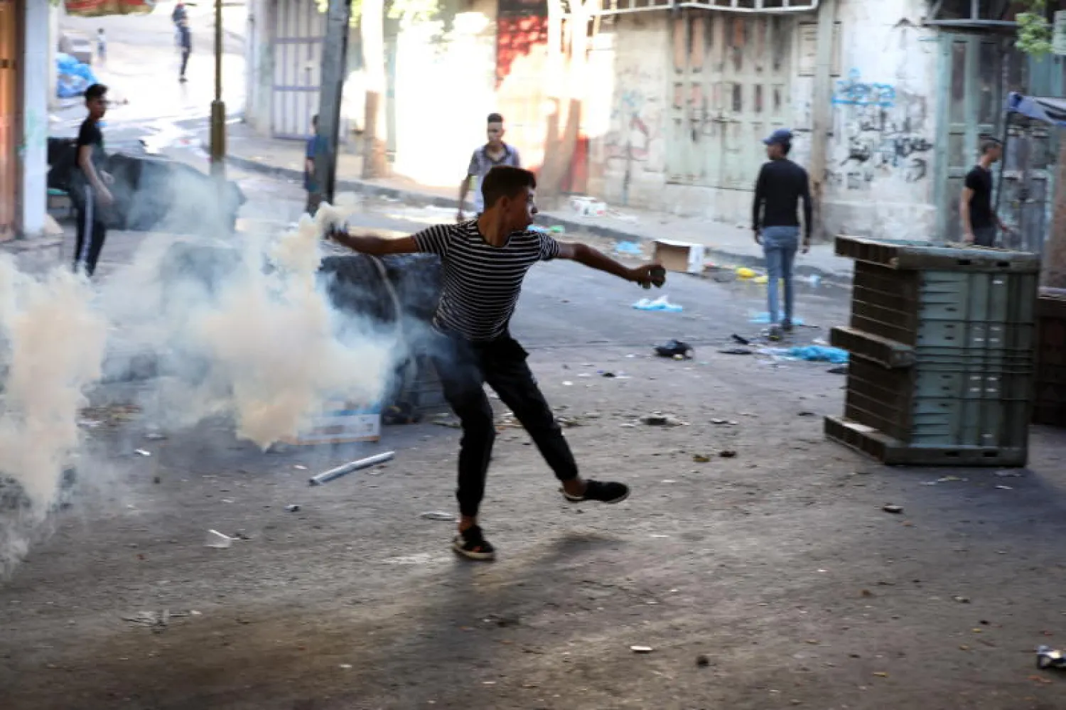 متظاهرون فلسطينيون يشتبكون مع جنود إسرائيليين في مدينة الخليل بالضفة الغربية (إ.ب.أ)