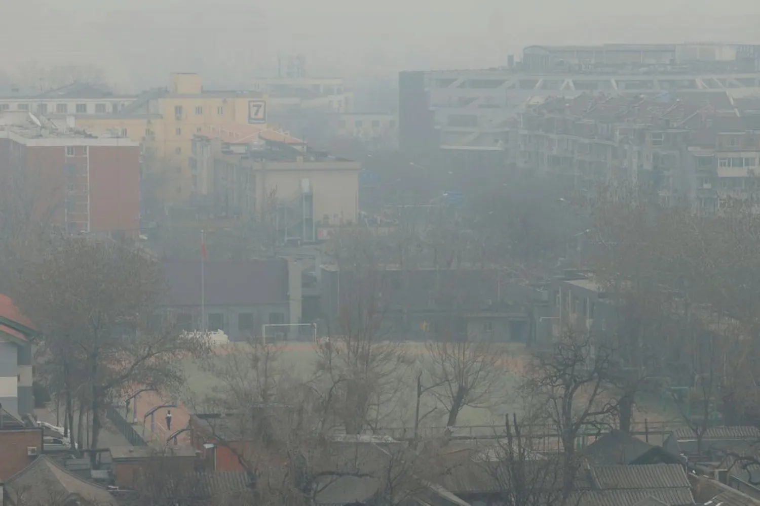 A student stands on a sports field shrouded in smog on a polluted day in Beijing, China March 10, 2021. REUTERS/Carlos Garcia Rawlins

