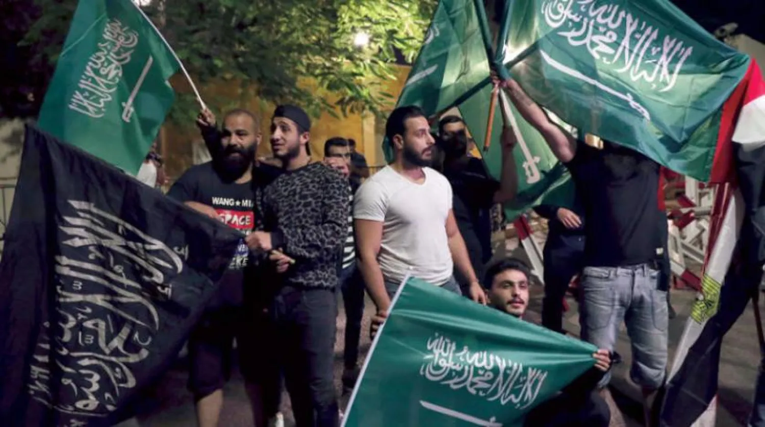 گزشتہ رات بیروت کے اندر لبنانی سعودی سفارت خانے کے سامنے سعودی پرچم اٹھائے ہوئے اس کے ساتھ اظہار یکجہتی کے لئے اور قرداحی کی بدسلوکی کو مسترد کرنے کے لئے جمع ہوئے اہل لبنان کو دیکھا جا سکتا ہے (اے پی)