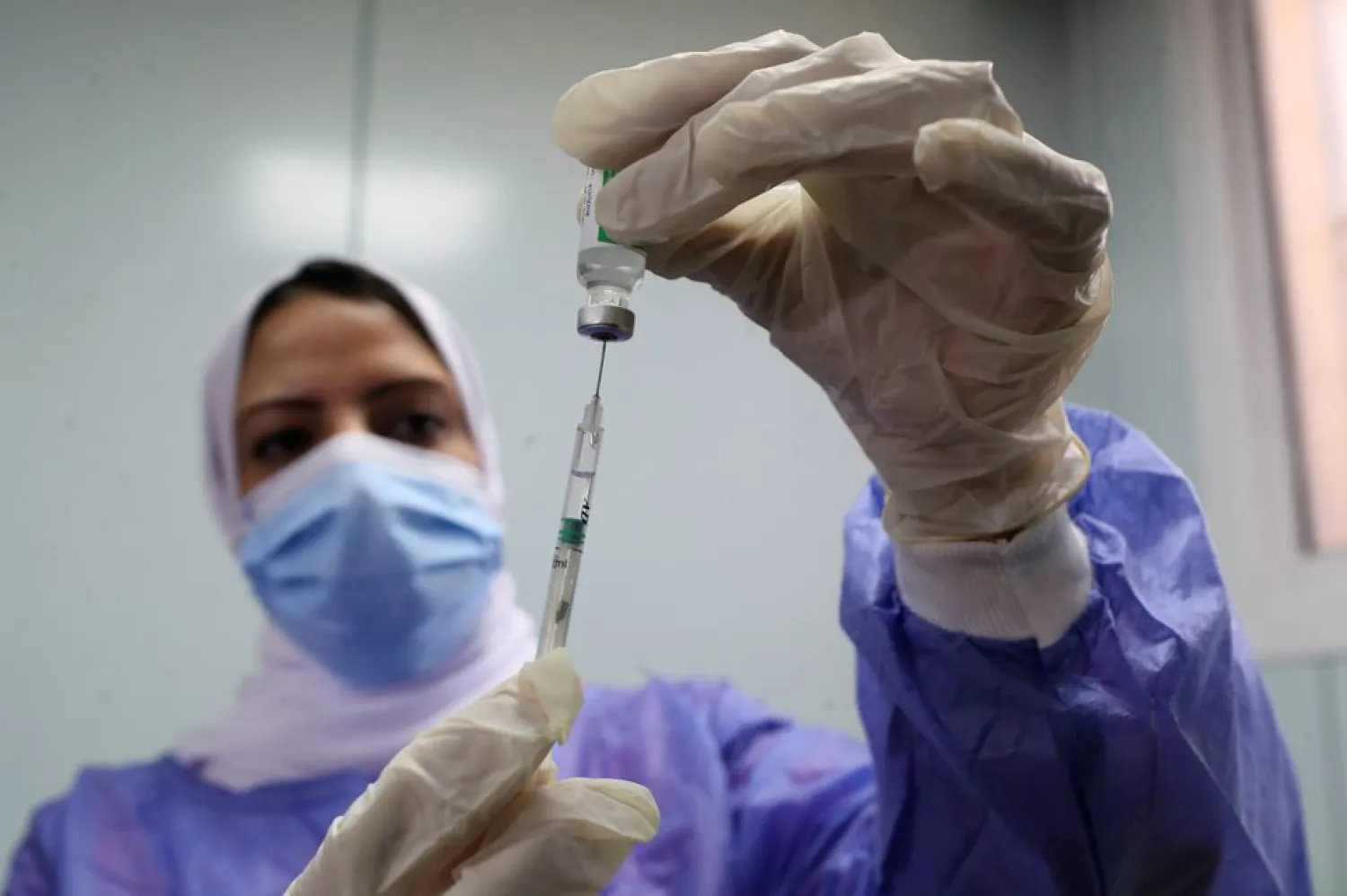 A healthcare worker holds a syringe and vaccine vial against the coronavirus disease (COVID-19) in Cairo, Egypt March 4, 2021. REUTERS/Mohamed Abd El Ghany/File Photo