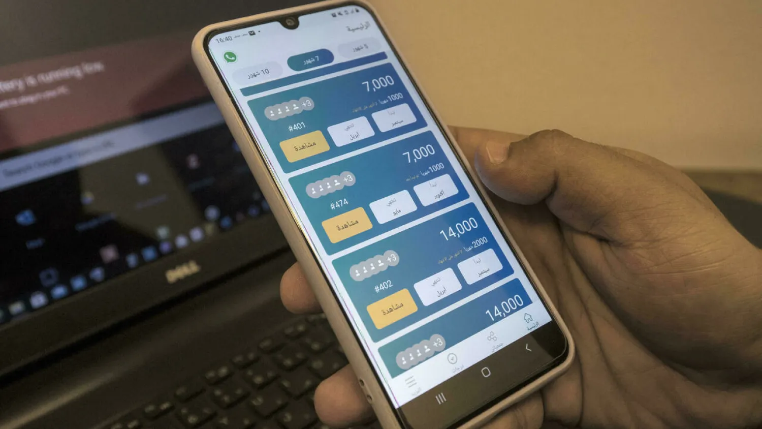 An employee of "Al-Gameya", a tech startup for money-pooling, holds a phone with the application at the company offices in Egypt’s capital Cairo. Khaled DESOUKI AFP
