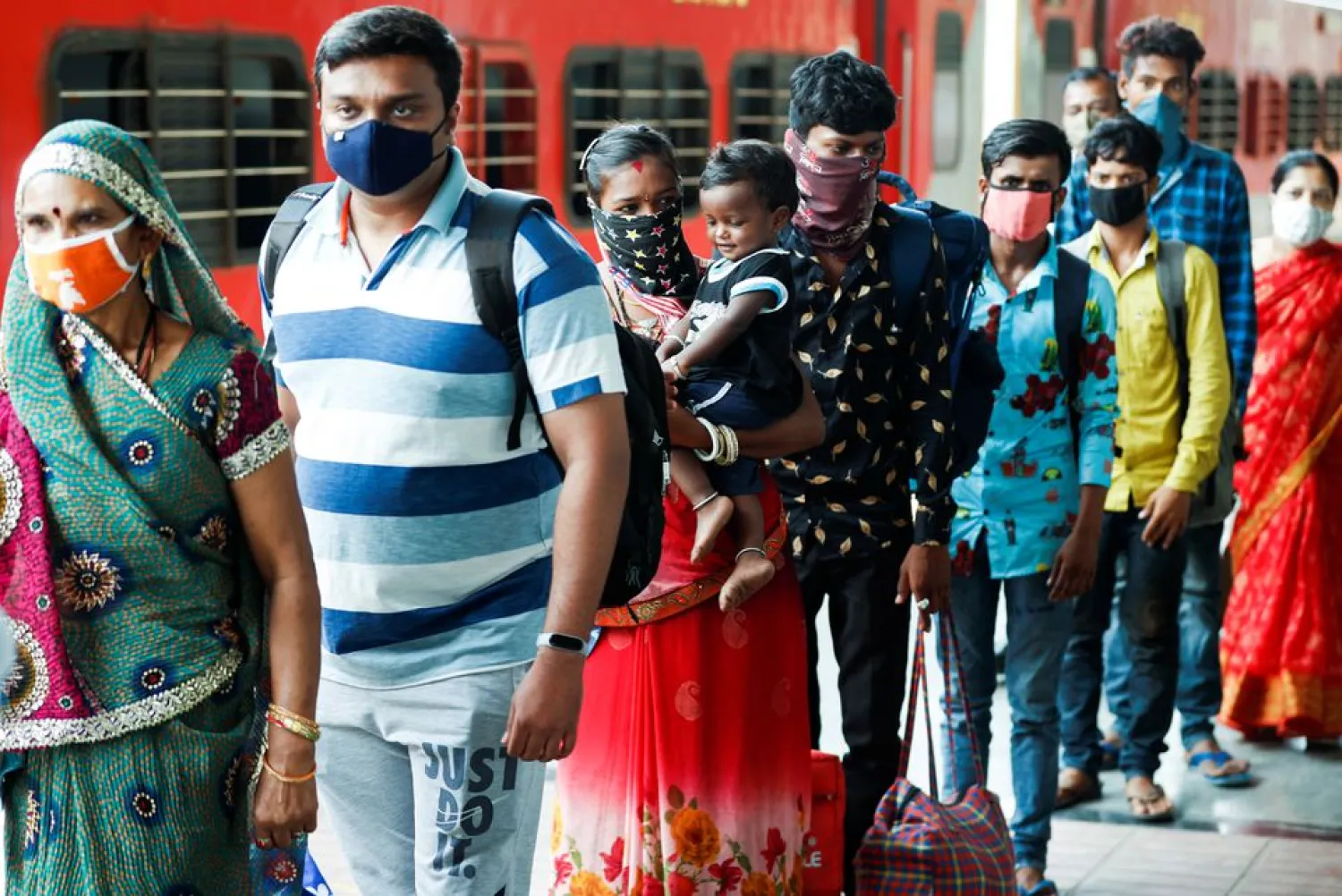 Commuters wait in a queue to have their temperature checked amidst the spread of the coronavirus disease (COVID-19) at a railway station in Mumbai, India, August 27, 2021. REUTERS/Francis Mascarenhas
