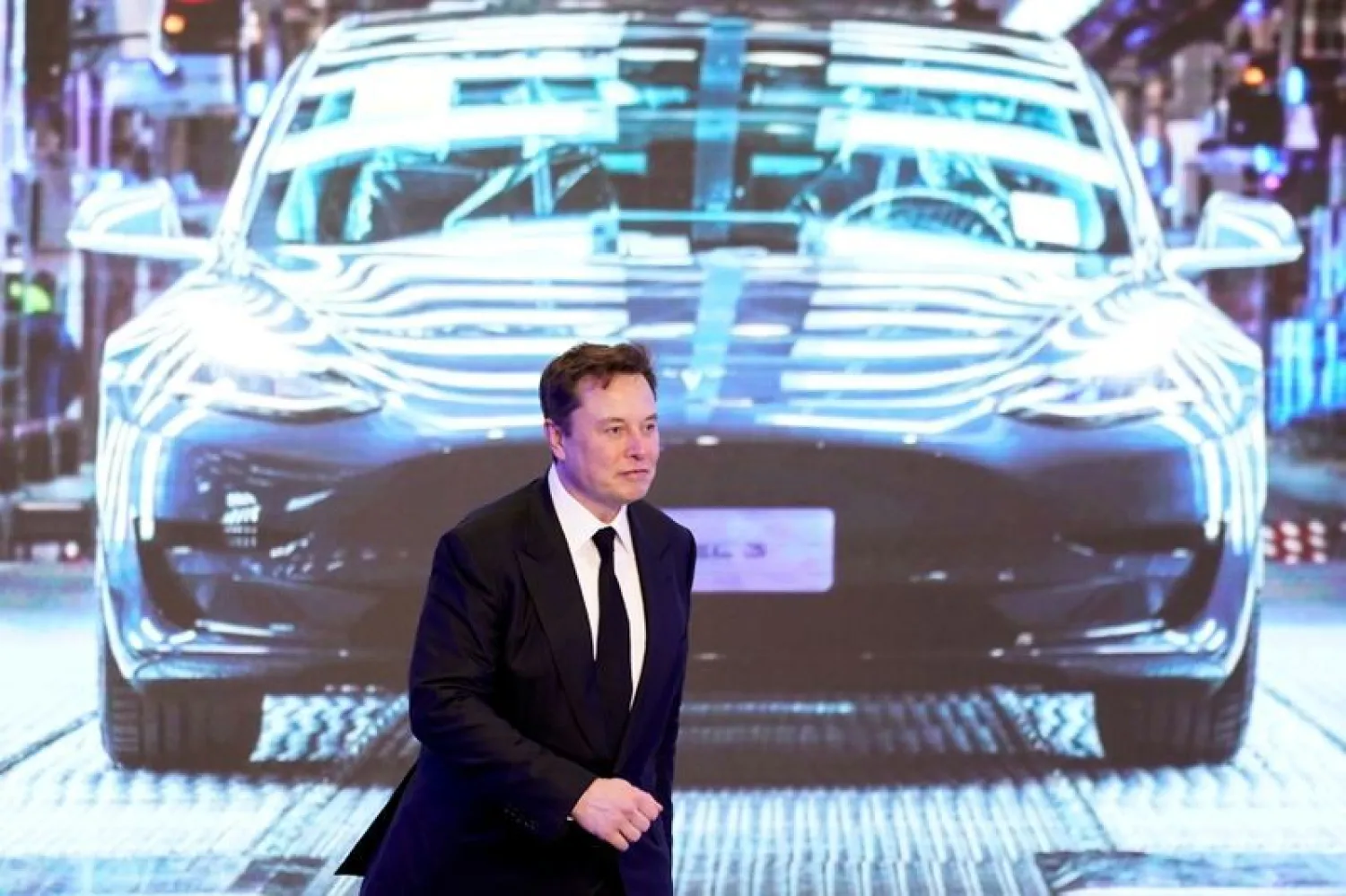 Tesla Inc CEO Elon Musk walks next to a screen showing an image of Tesla Model 3 car during an opening ceremony for Tesla China-made Model Y program in Shanghai, China January 7, 2020. REUTERS/Aly Song/File Photo
