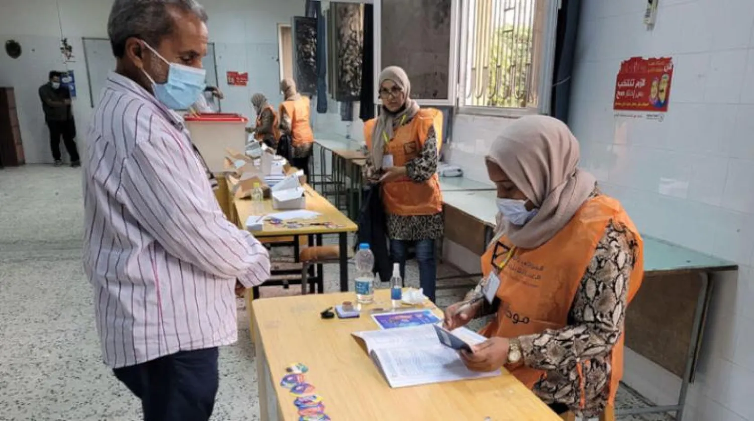 A Libyan man registers his personal information to receive a voter card for the December elections. (AFP)