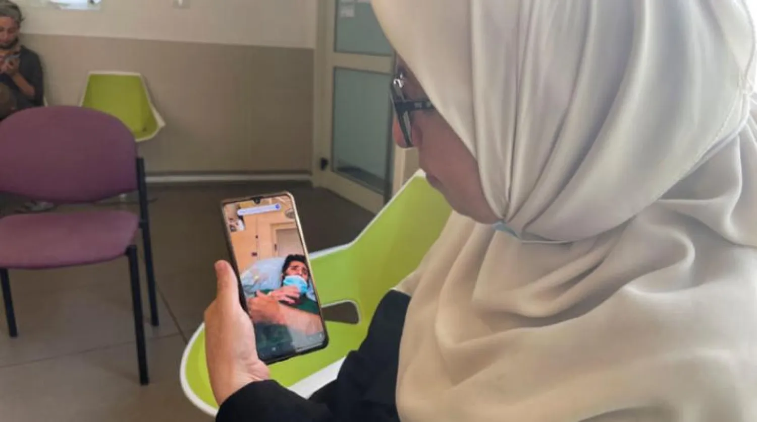 Mother of Miqdad Qawasmeh, who has been on a hunger strike for more than 100 days, speaks with him over the phone (Reuters) 
