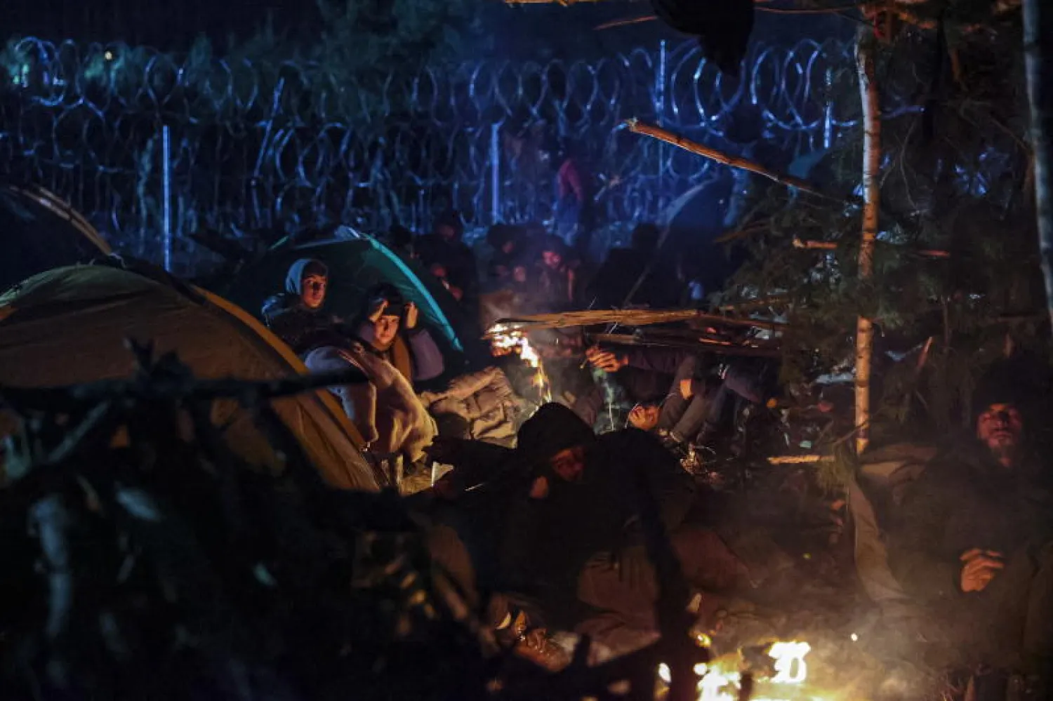 مهاجرون في معسكر على الحدود البيلاروسية البولندية (إ.ب.أ)