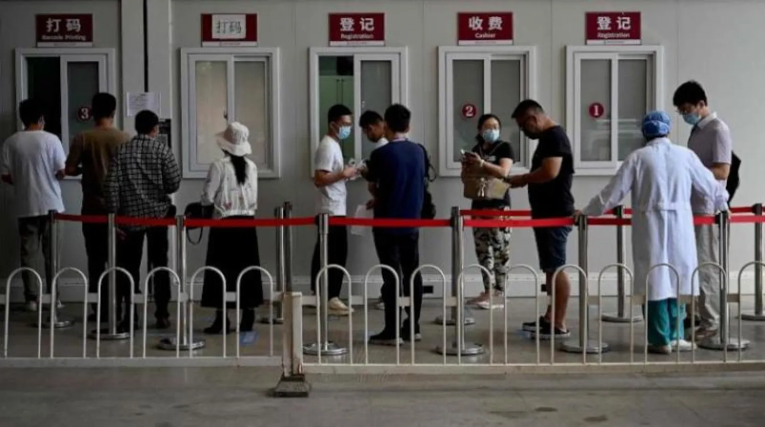 أشخاص يصطفون لاختبار فيروس كورونا أمام مستشفى تشاويانغ في بكين (أ.ف.ب)
