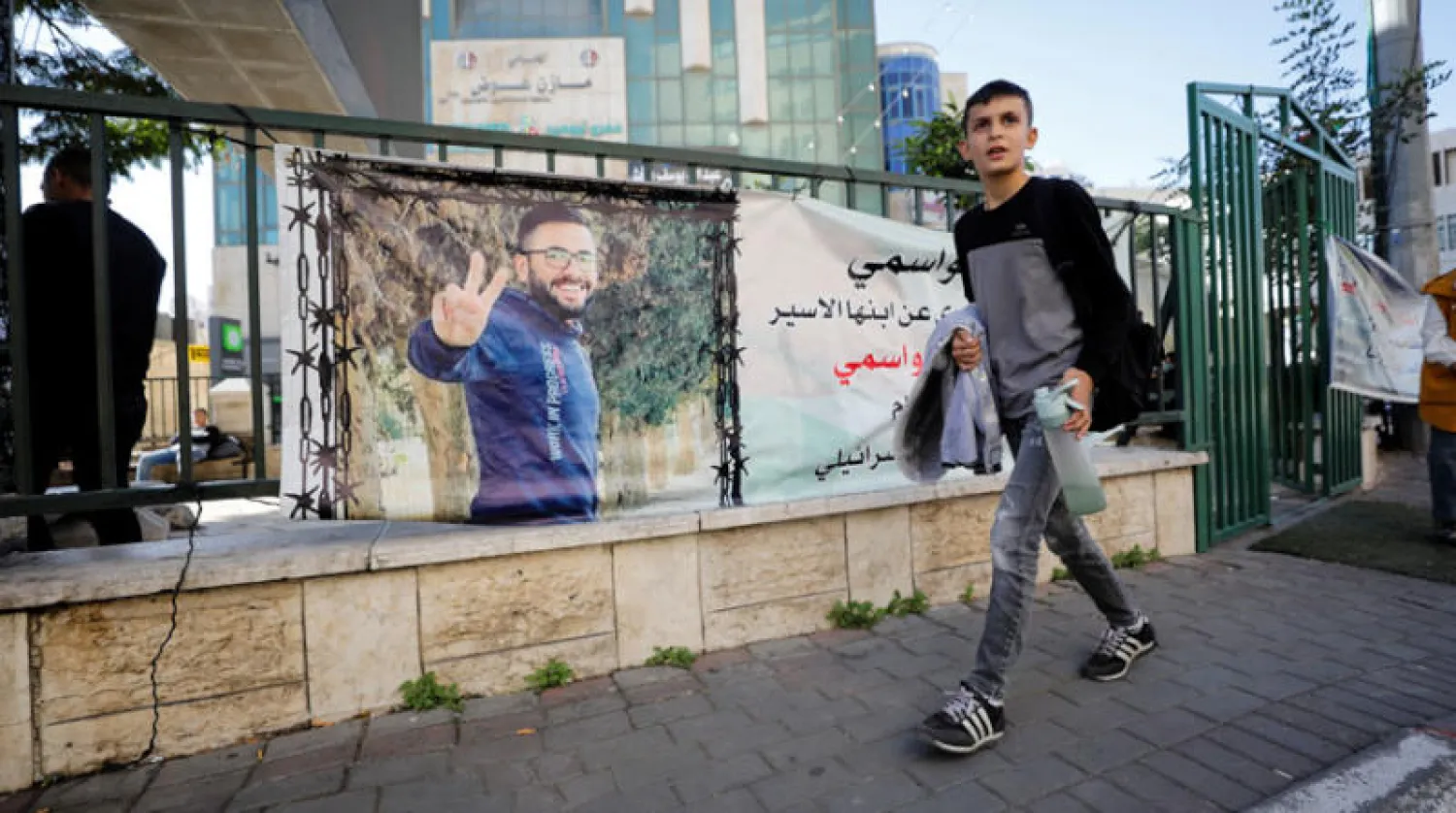 لافتة تضامن مع الأسير مقداد القواسمي على جدار في الخليل (رويترز)