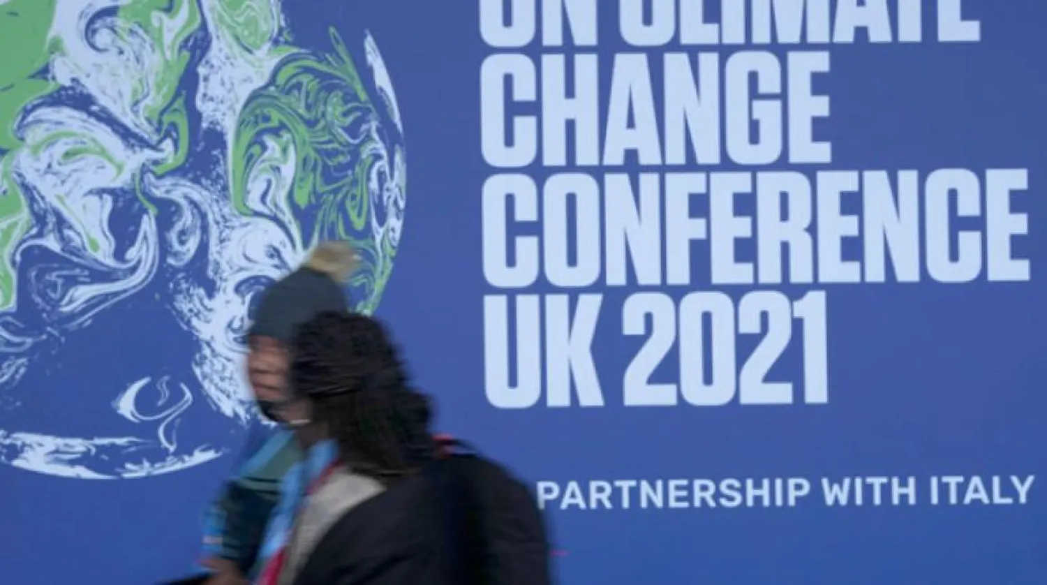 Participants pass a sign at the venue of the COP26 conference in Glasgow, Scotland. (AP) 
