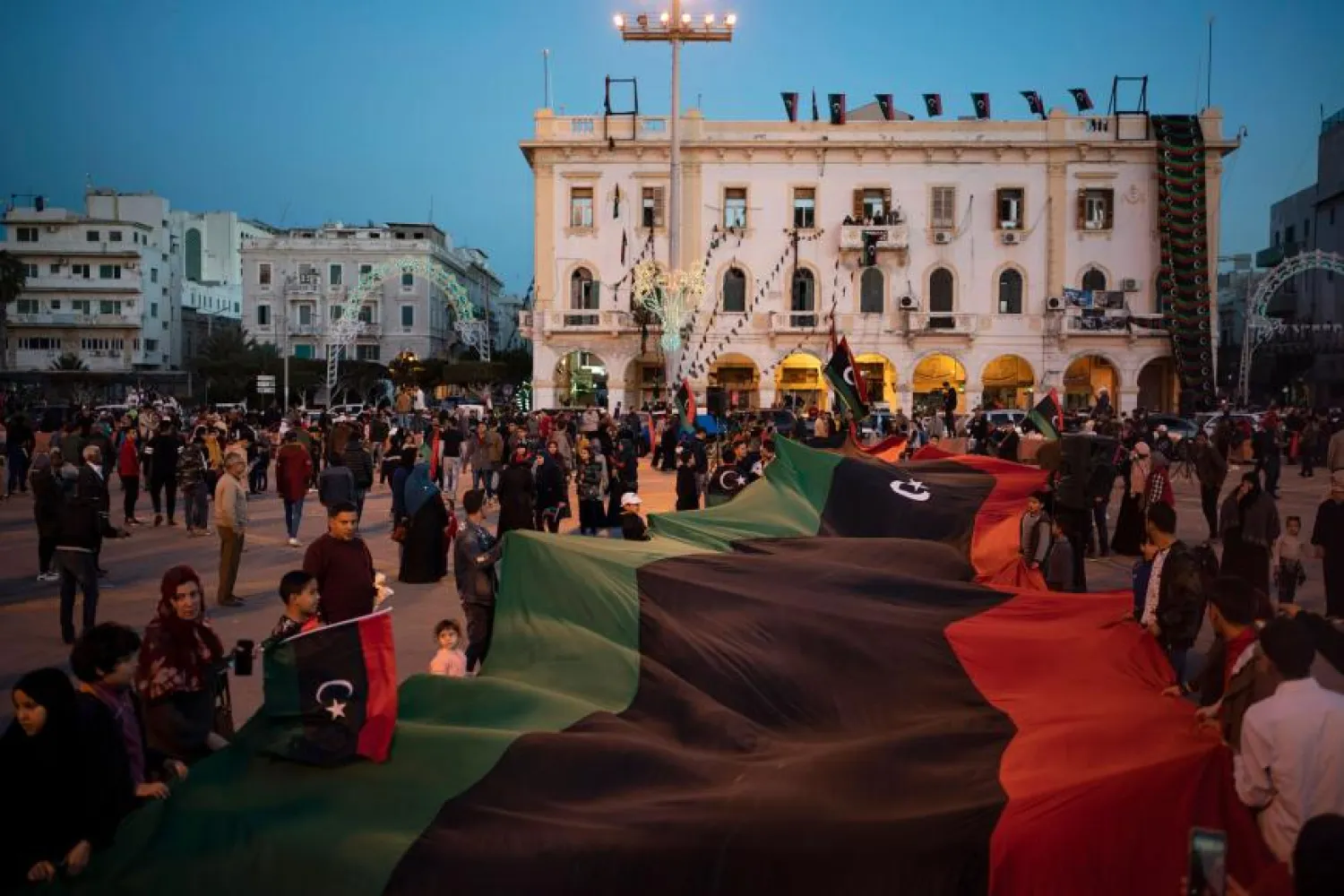 People carry a Libyan flag at Martyr square during a march commemorating the anniversary of protests in Tripoli, Libya, February 25, 2020. AP Photo/Felipe Dana, File 