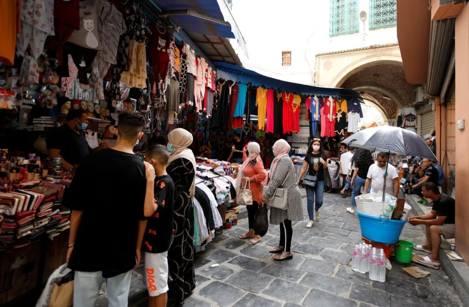 People walk past shops in the Medina, in the Old City of Tunis, Tunisia, July 27, 2021. Picture taken July 27, 2021. (Reuters)