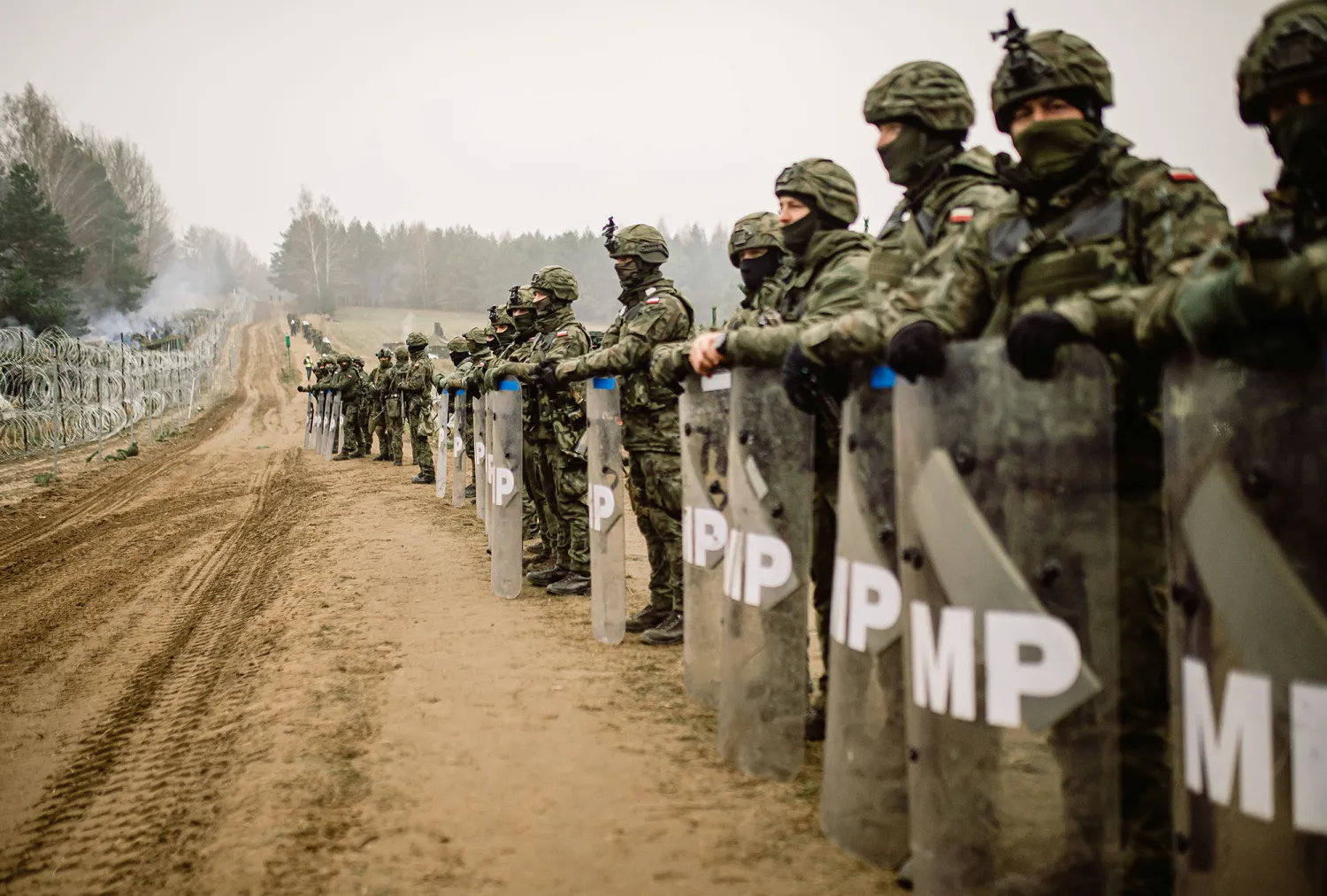 Polish military police stay on guard at the Poland/Belarus border near Kuznica, Poland, in this photograph released by the Territorial Defense Forces, November 12, 2021. Irek Dorozanski/DWOT/Handout via Reuters 