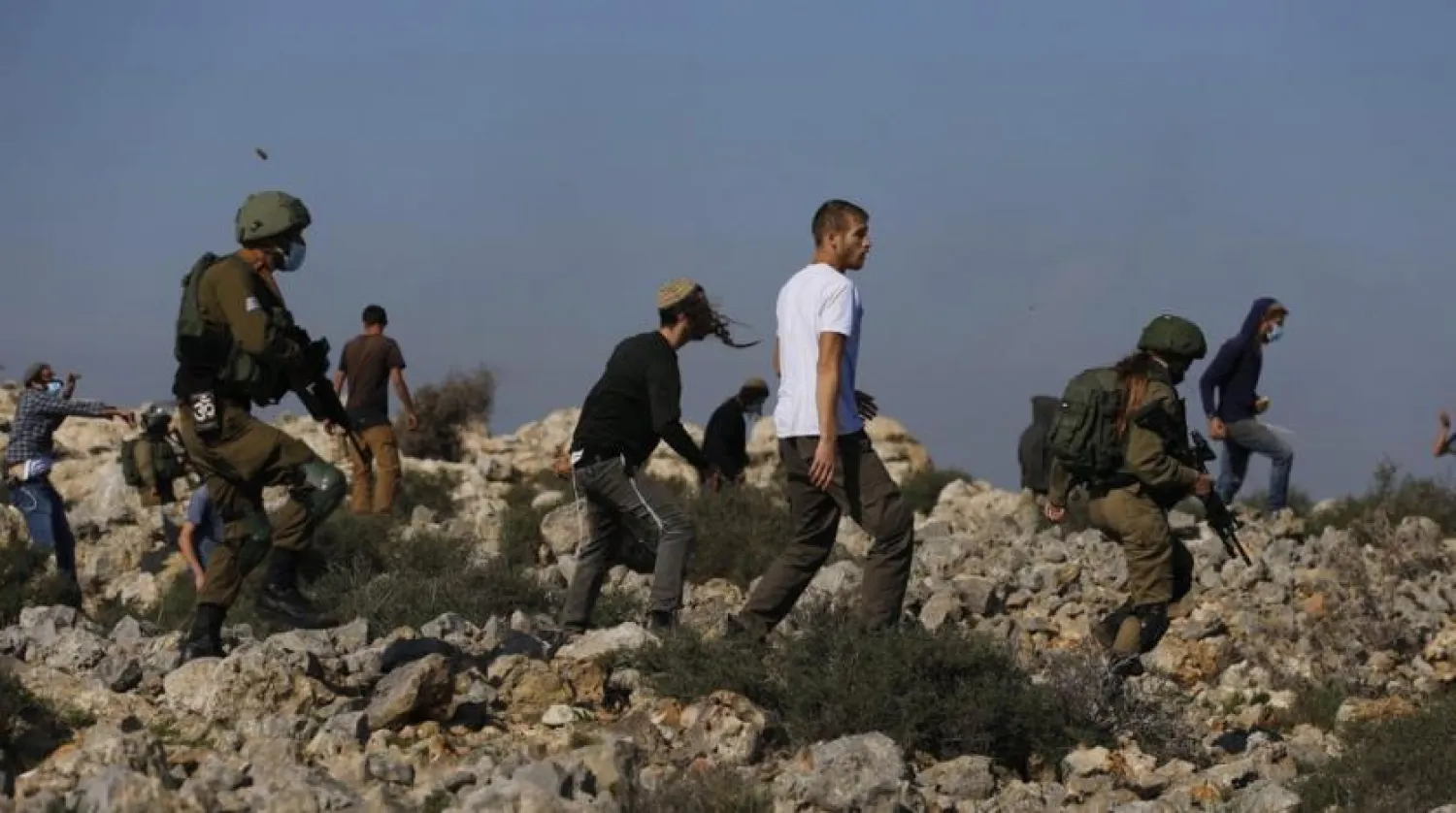 Israeli soldiers and settlers clash with Palestinians during a protest against the expansion of Jewish settlements near the West Bank town of Salfit, Monday, Nov. 30, 2020. (AP Photo/Majdi Mohammed)
