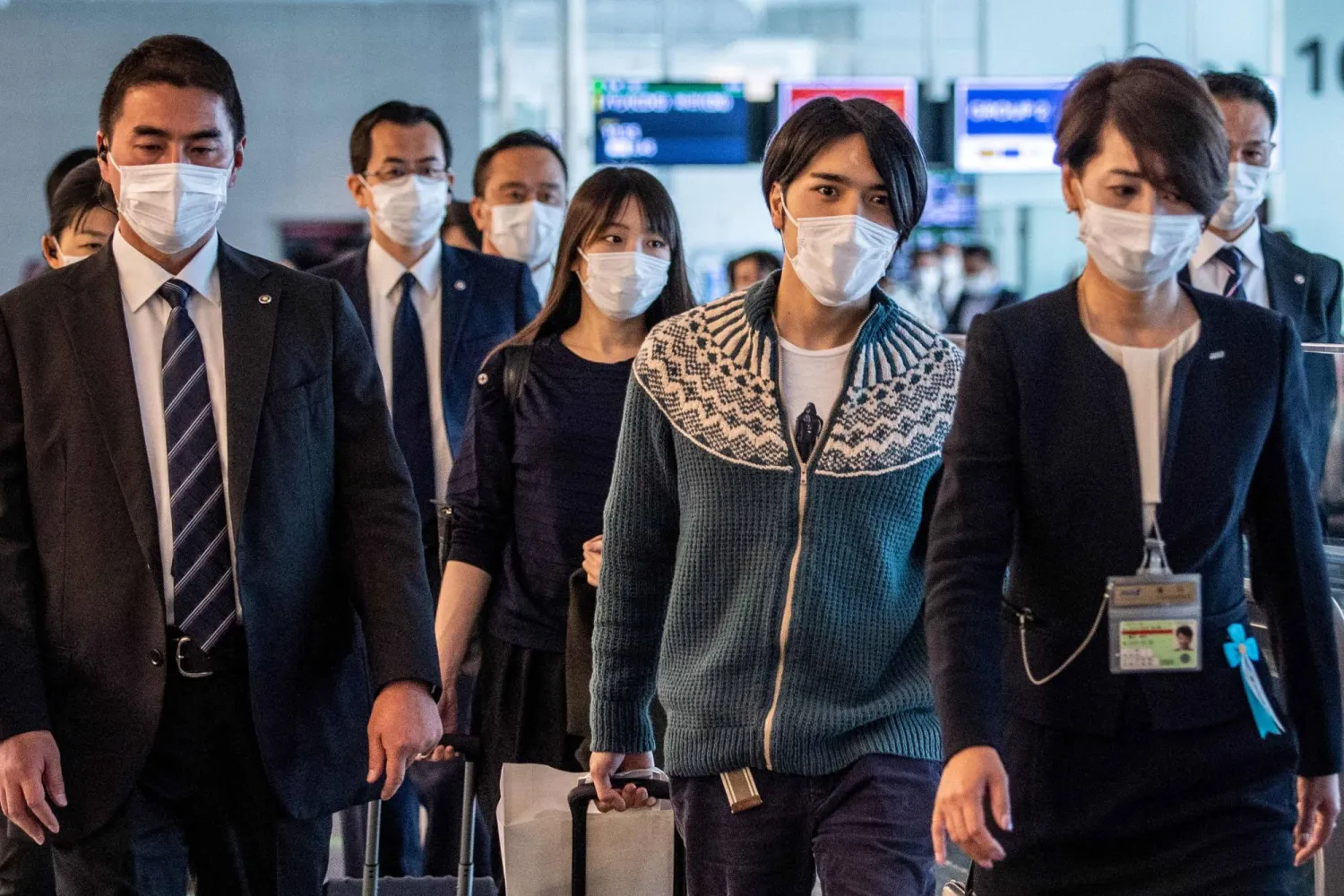 Former Princess Mako Komuro (center) and her husband Kei Komuro (second from right) walk to their departure gate for their flight to New York at Tokyo's Haneda Airport on Sunday. AFP-JIJI