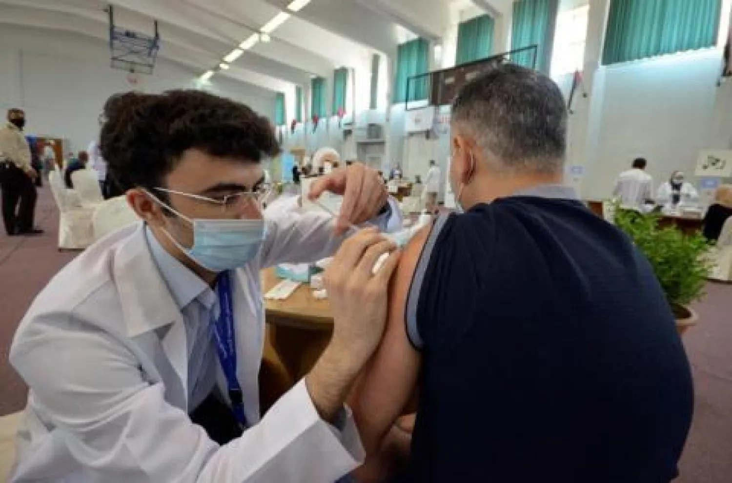 عامل صحي يعطي جرعة من لقاح «كورونا» لرجل في الأردن (أرشيفية - رويترز)