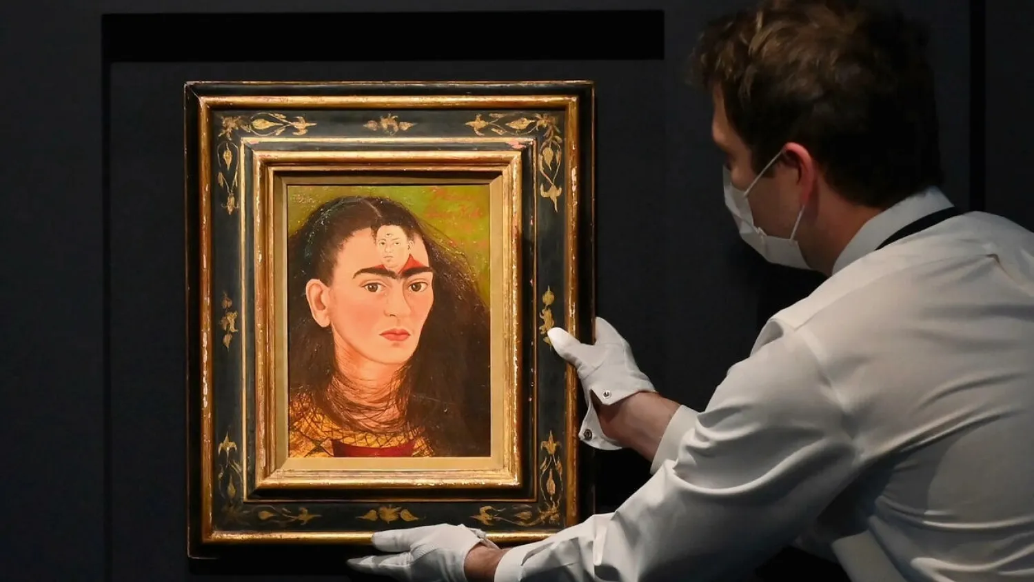 A Sotheby's worker arranges the Frida Kahlo self-portrait "Diego y yo," in New York on November 15, 2021. ANGELA WEISS AFP
