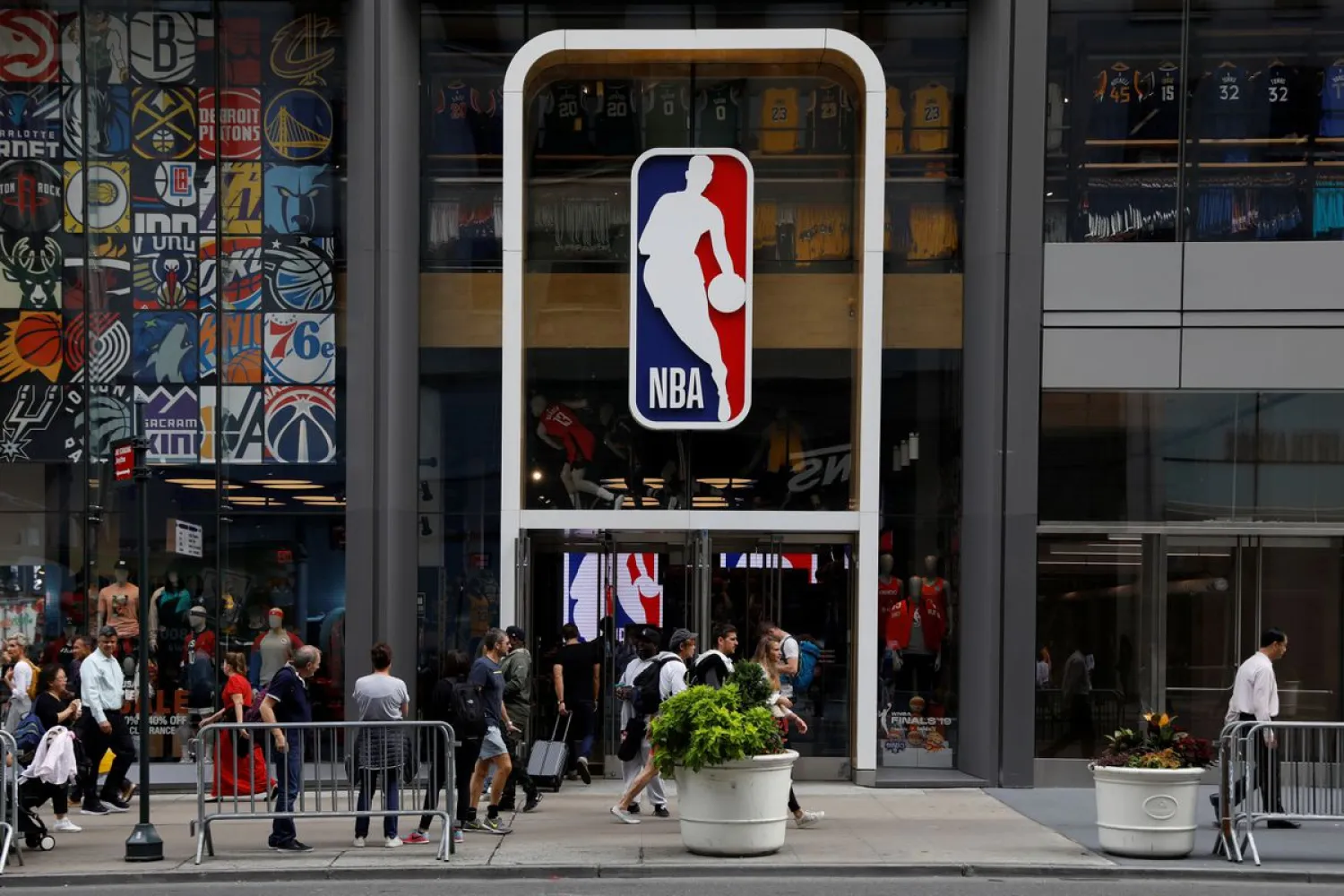 The NBA logo is displayed as people pass by the NBA Store in New York City, US, October 7, 2019. REUTERS/Brendan McDermid